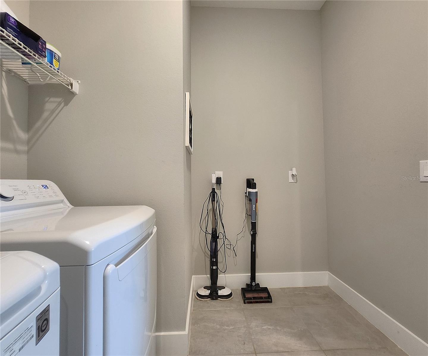 Interior Laundry Room includes side-by-side washer and dryer, ventilated shelves, and storage space