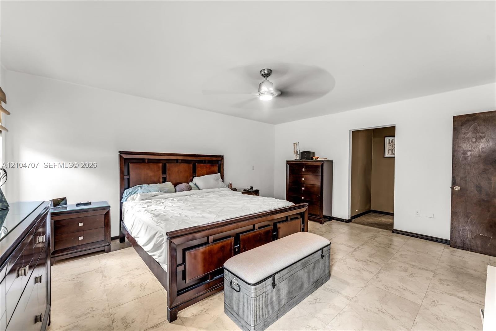 Neutral-toned tile flooring, ceiling fan with integrated lighting, and mirrored closet doors