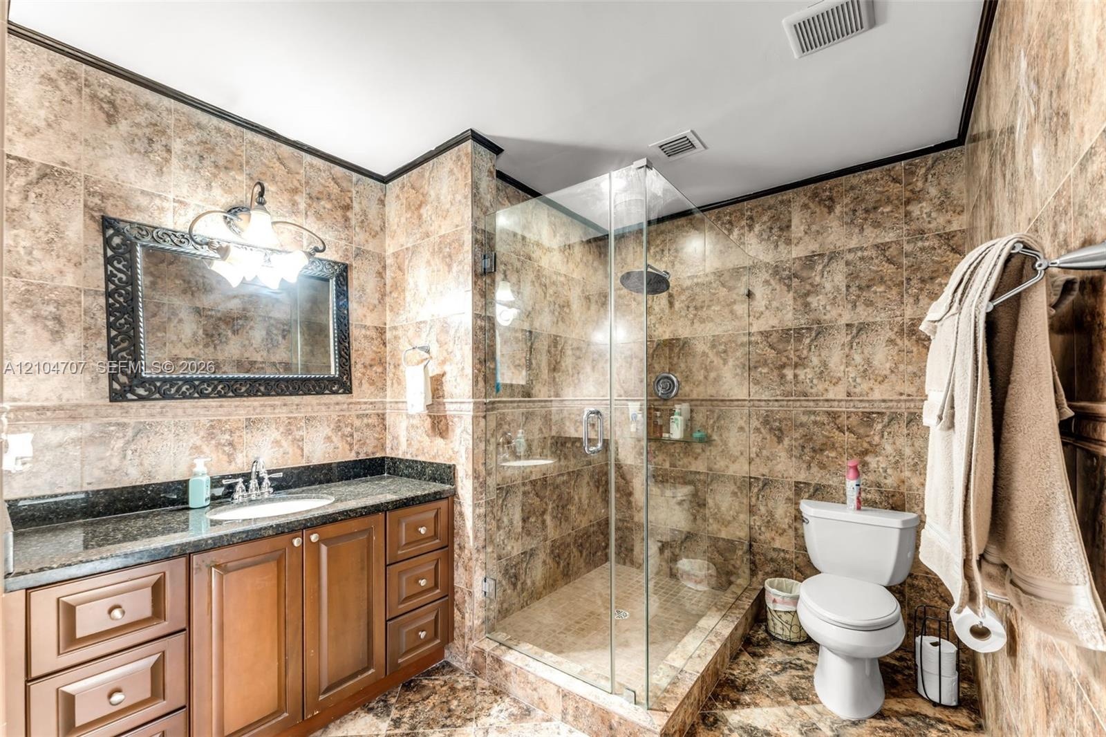 Room featuring large-format neutral tile flooring, a central ceiling fan with integrated light fixture, and horizontal window blinds