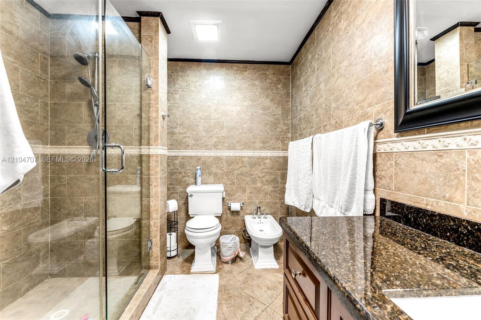 Neutral-toned interior featuring tile flooring, a multi-blade ceiling fan with integrated lighting, and dual windows equipped with woven shades
