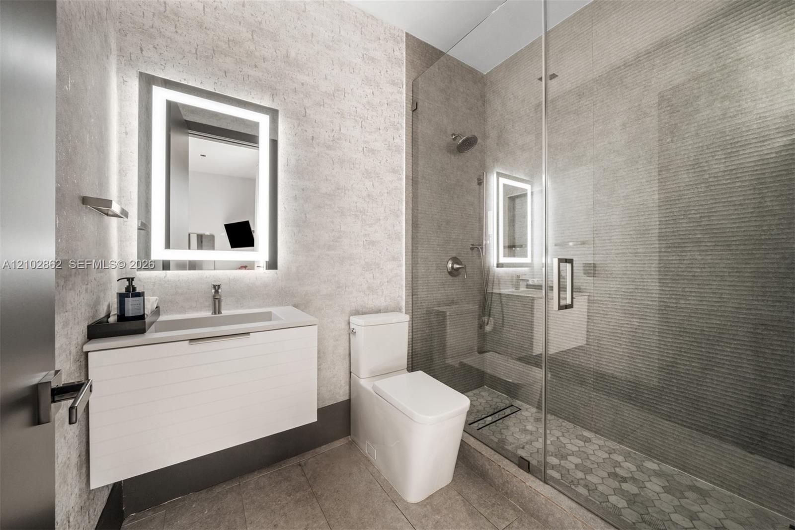 Bedroom featuring textured accent wall, floor-to-ceiling windows, recessed lighting, and wood-finish flooring