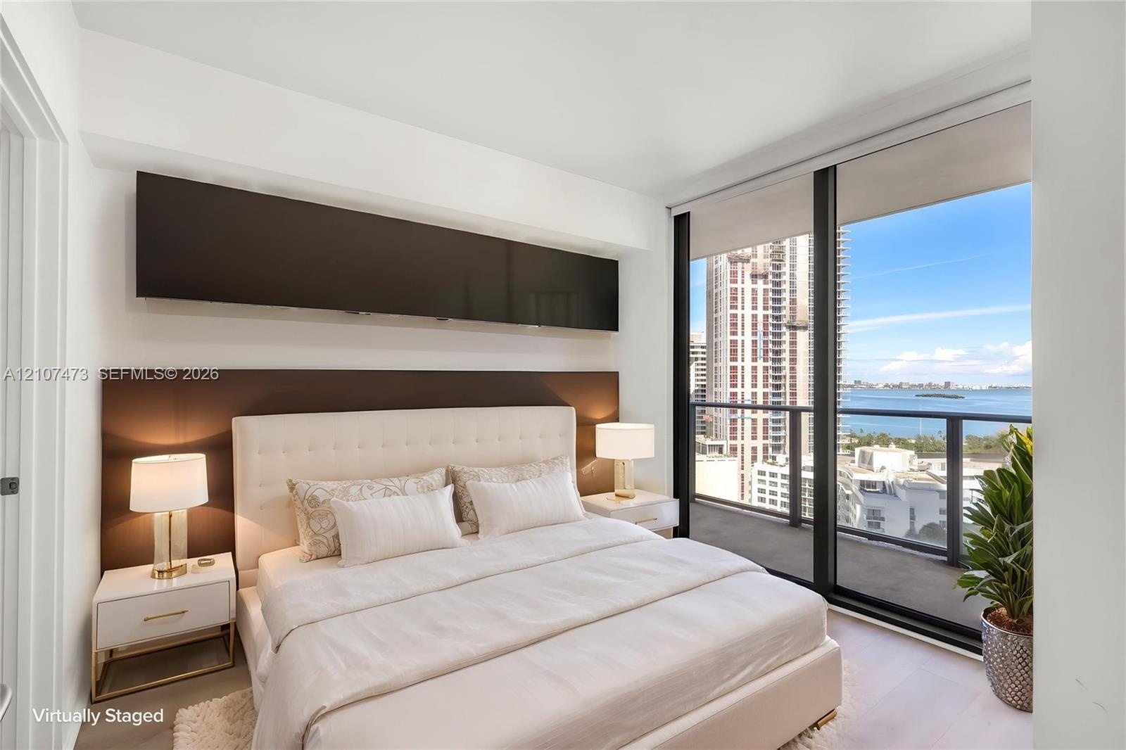 Floor-to-ceiling windows, built-in horizontal cabinetry, wood-finish flooring, and a private balcony