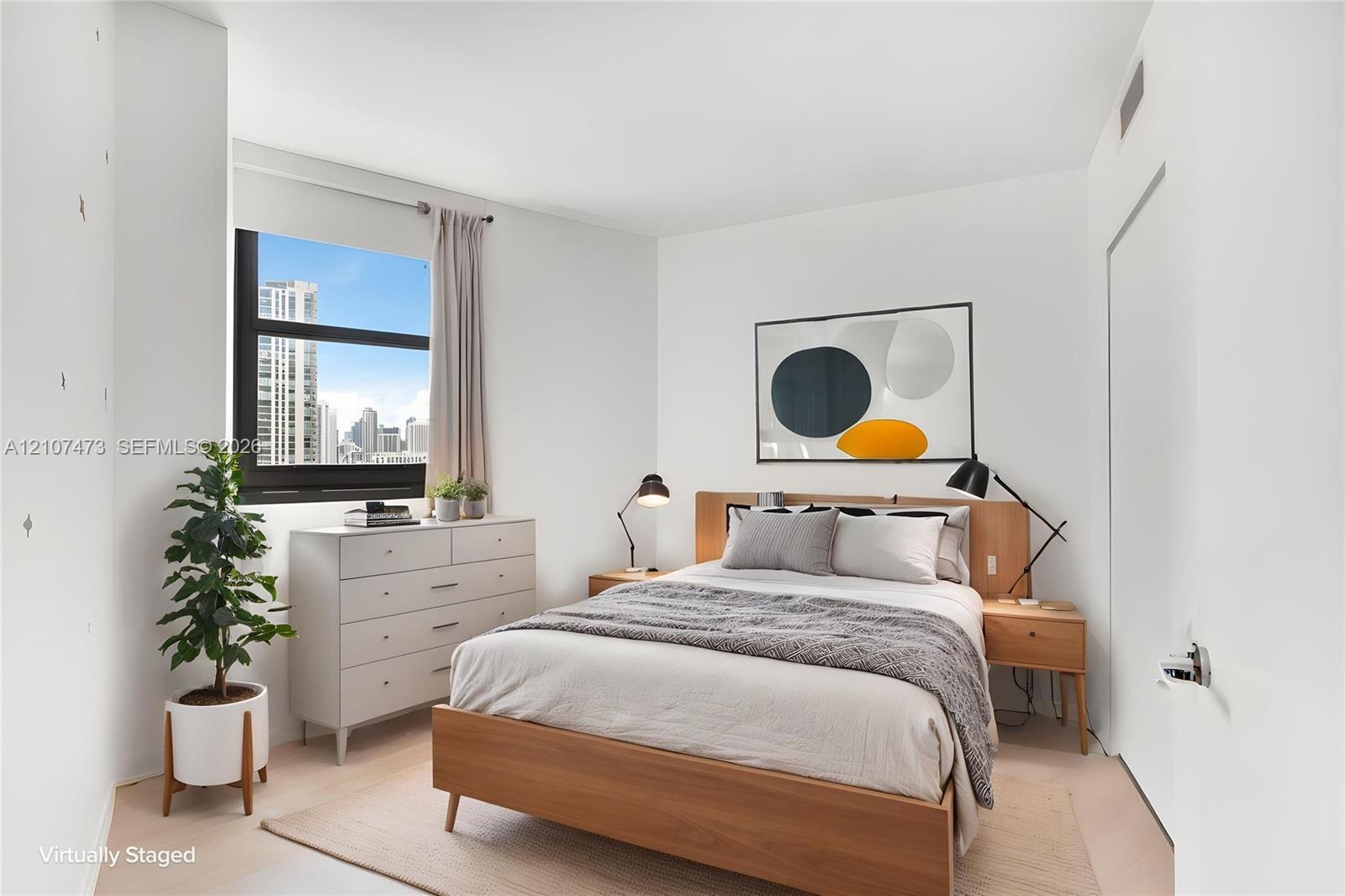 Neutral-toned walls, large window with urban exterior, and light-tone wood-finish flooring