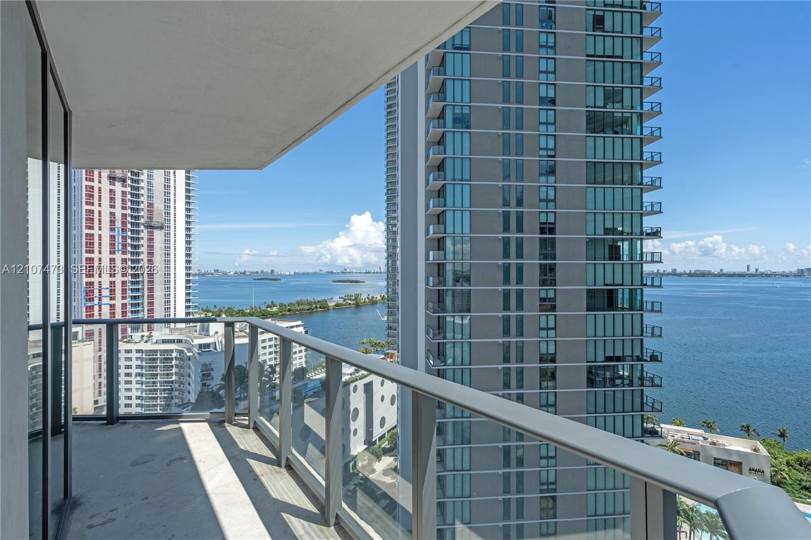 Covered balcony featuring concrete flooring and a glass-panel railing with a metal frame
