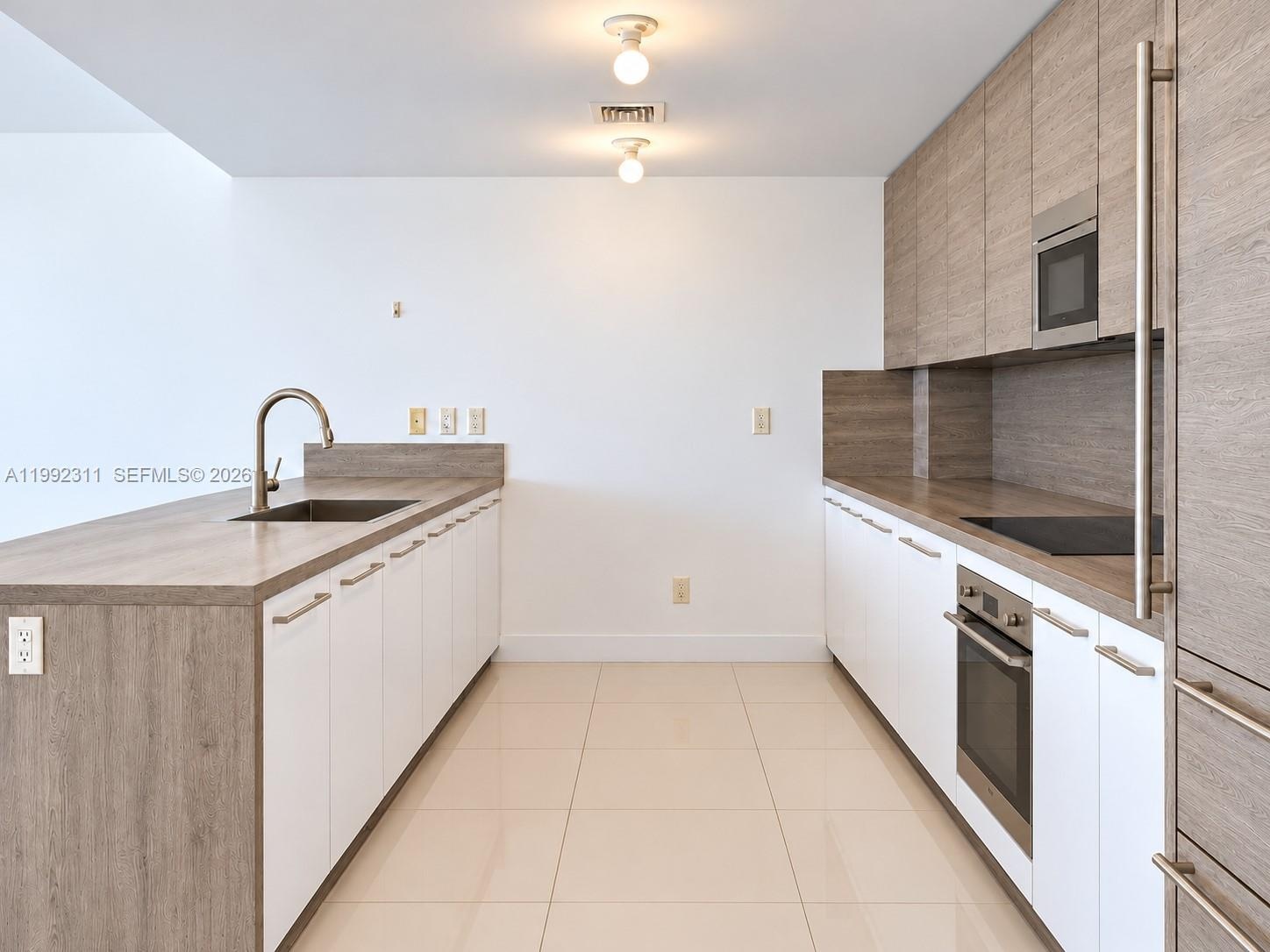 Covered terrace featuring large-format tile flooring, glass panel railings, and privacy screening