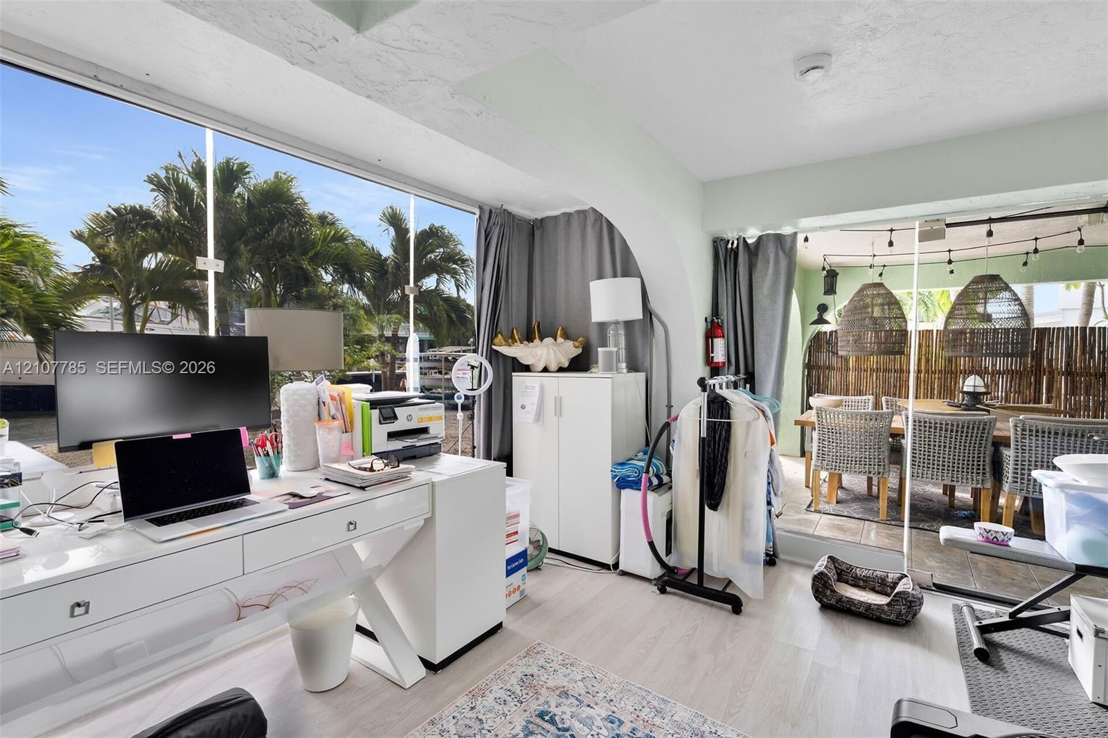 Floor-to-ceiling windows, light-toned wood-finish flooring, and arched architectural detailing