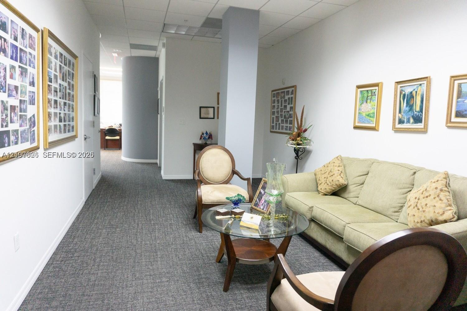 Interior space featuring a curved architectural wall, grey patterned carpeting, and a central structural column