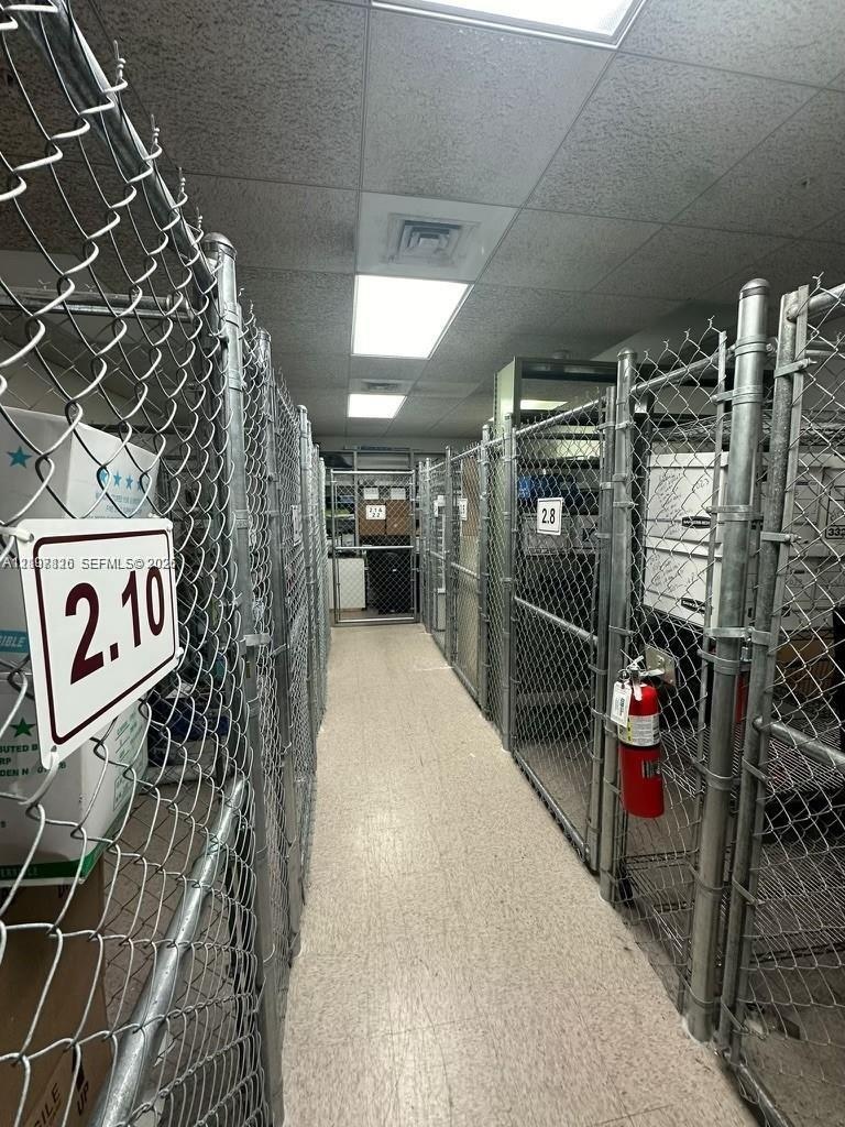 Storage area featuring wire mesh partitions, drop ceiling with recessed lighting, and resilient composite tile flooring