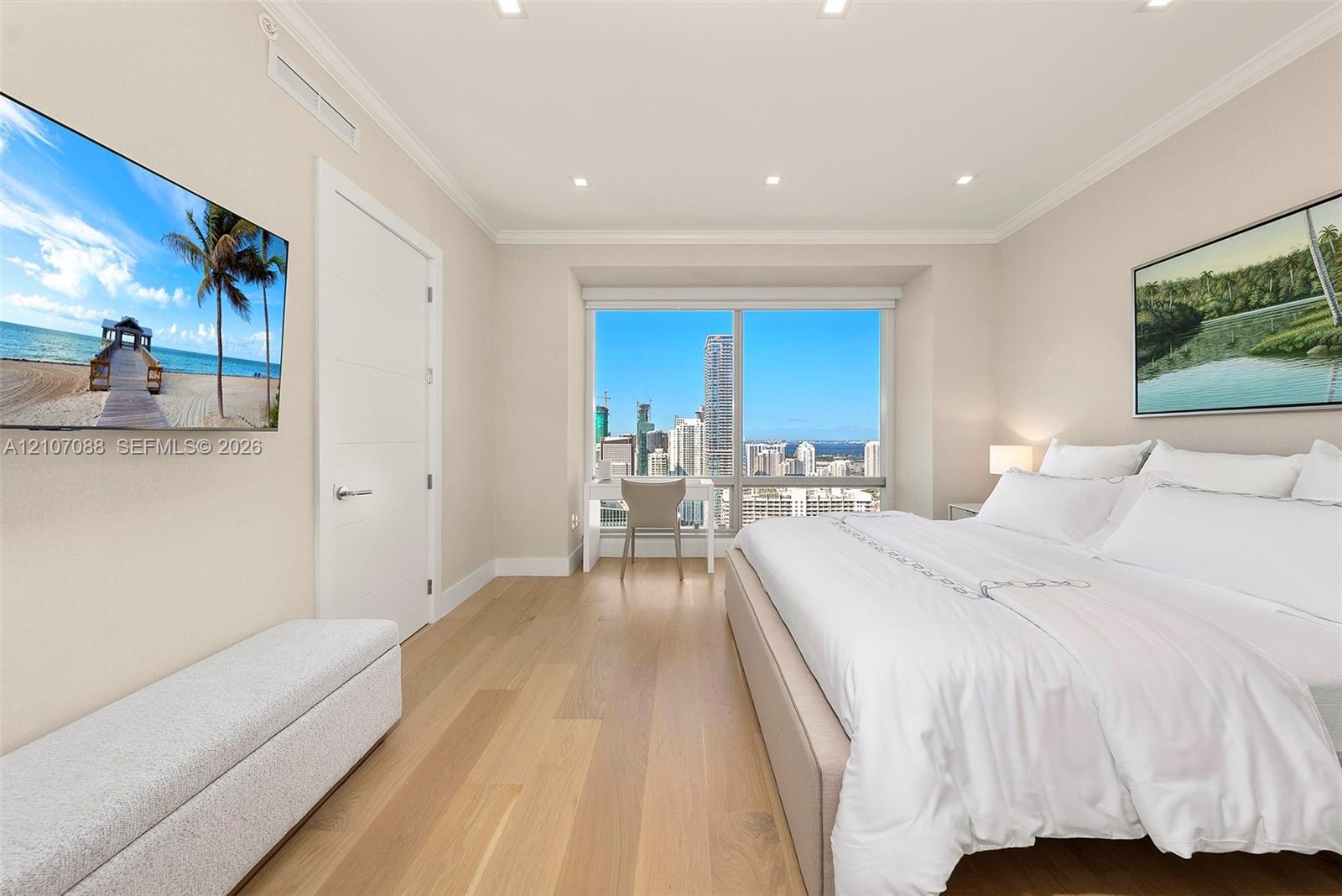 Floor-to-ceiling windows featuring urban skyline imagery, wide-plank wood-finish flooring, recessed ceiling lighting