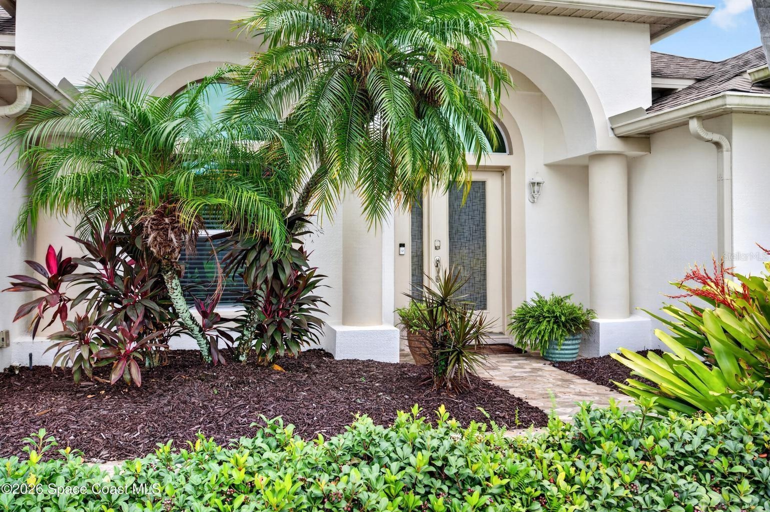Arched entry, tropical landscaping
