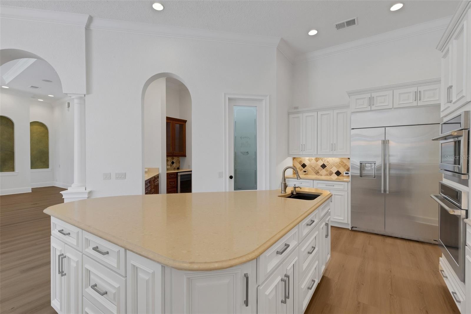 a large central island with an additional prep-sink, walk-in pantry and butler's pantry & bar alcove.