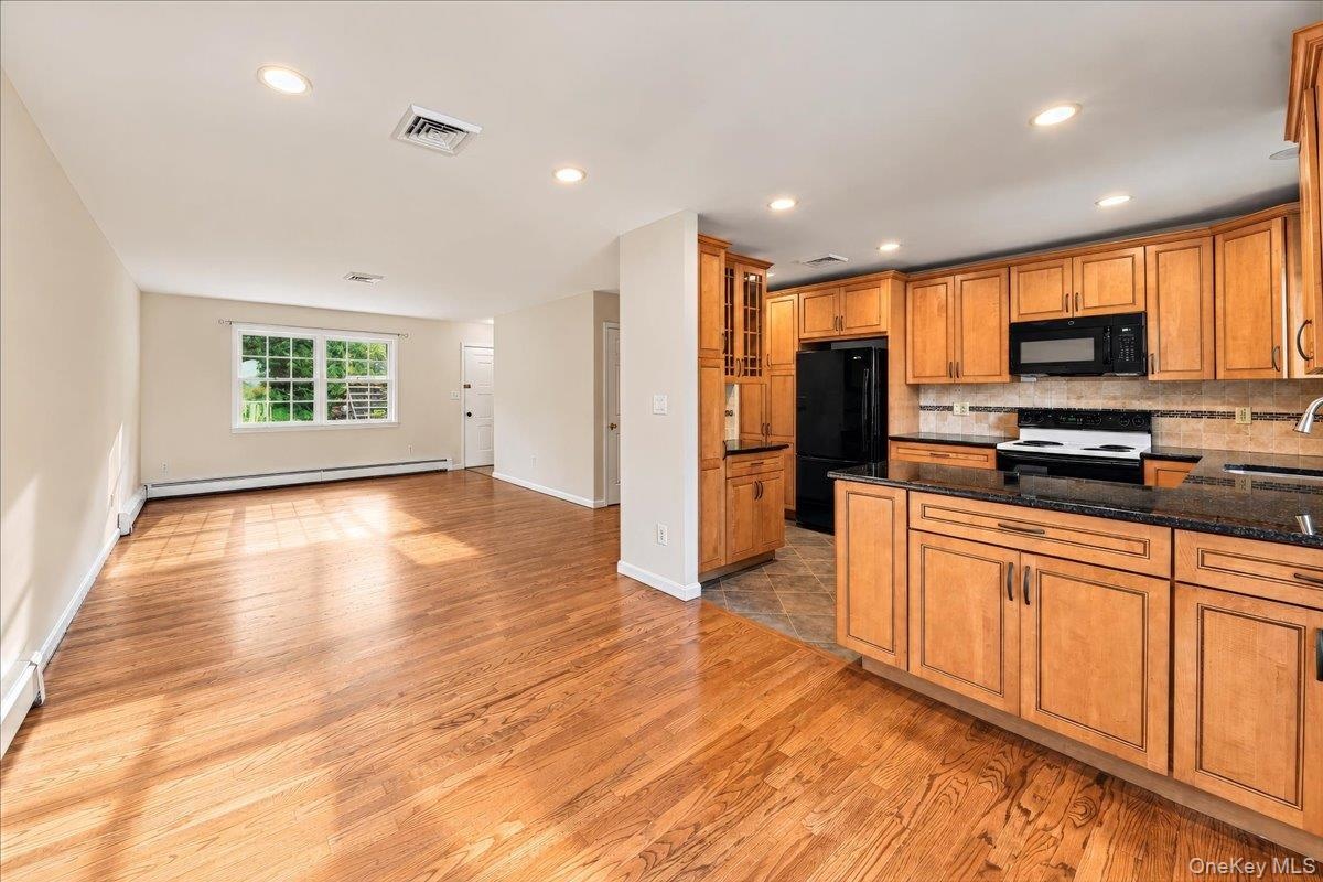 An inviting open floor plan seamlessly connects the kitchen, dining room, and living room, creating a bright and airy space ideal for everyday living 
