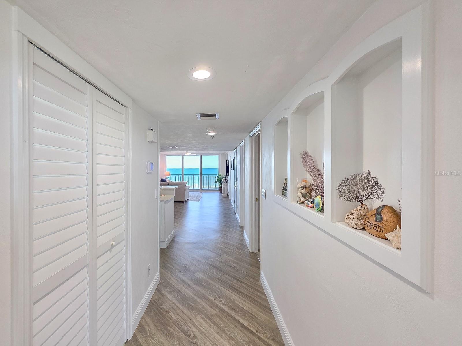 Hallway with laundry on left and built-ins on left.