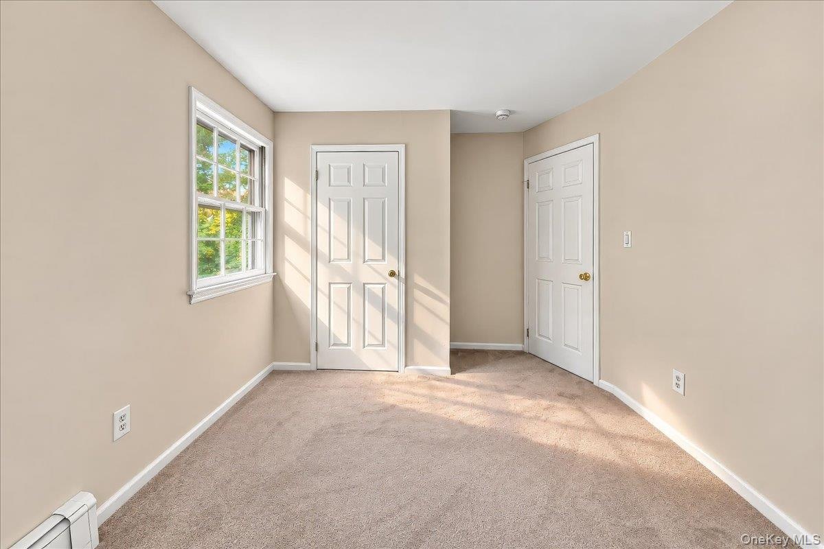 Bright, refreshed bedroom featuring brand-new carpeting and a fresh coat of paint, creating a clean and inviting space.