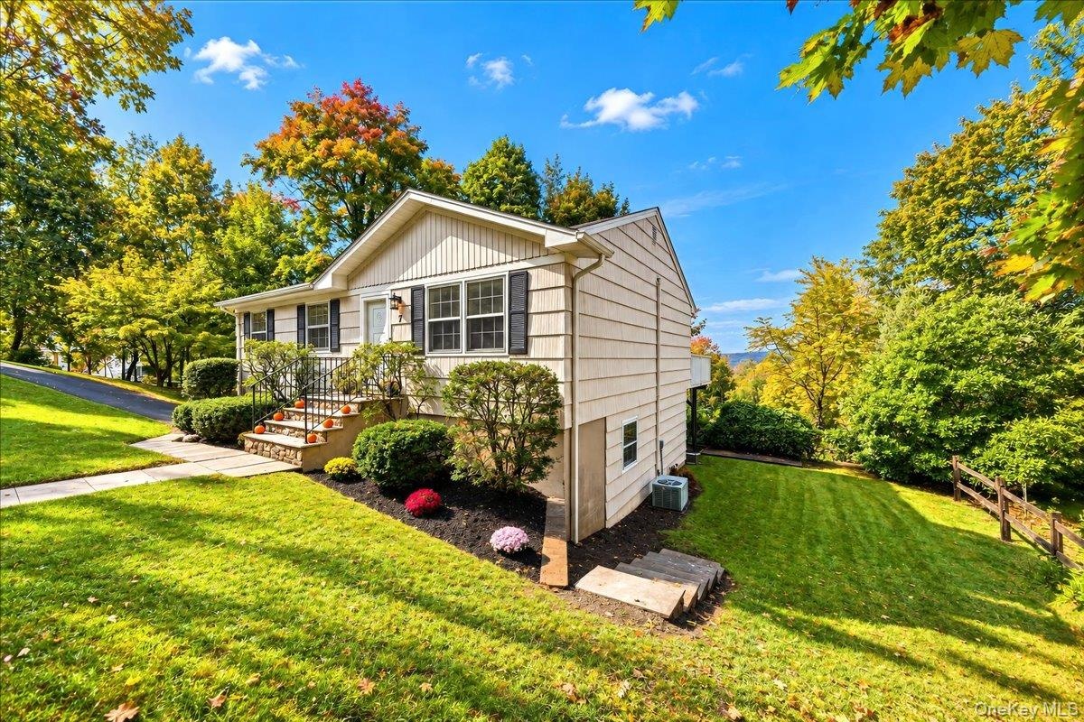 Side yard with neatly maintained landscaping and a freshly painted exterior, offering a welcoming path around to the back of the home.