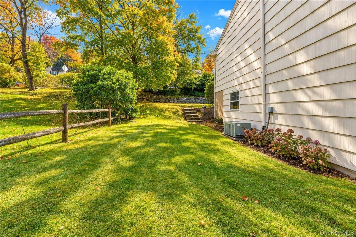Side yard with neatly maintained landscaping and a freshly painted exterior, offering a welcoming path to the front of the home.