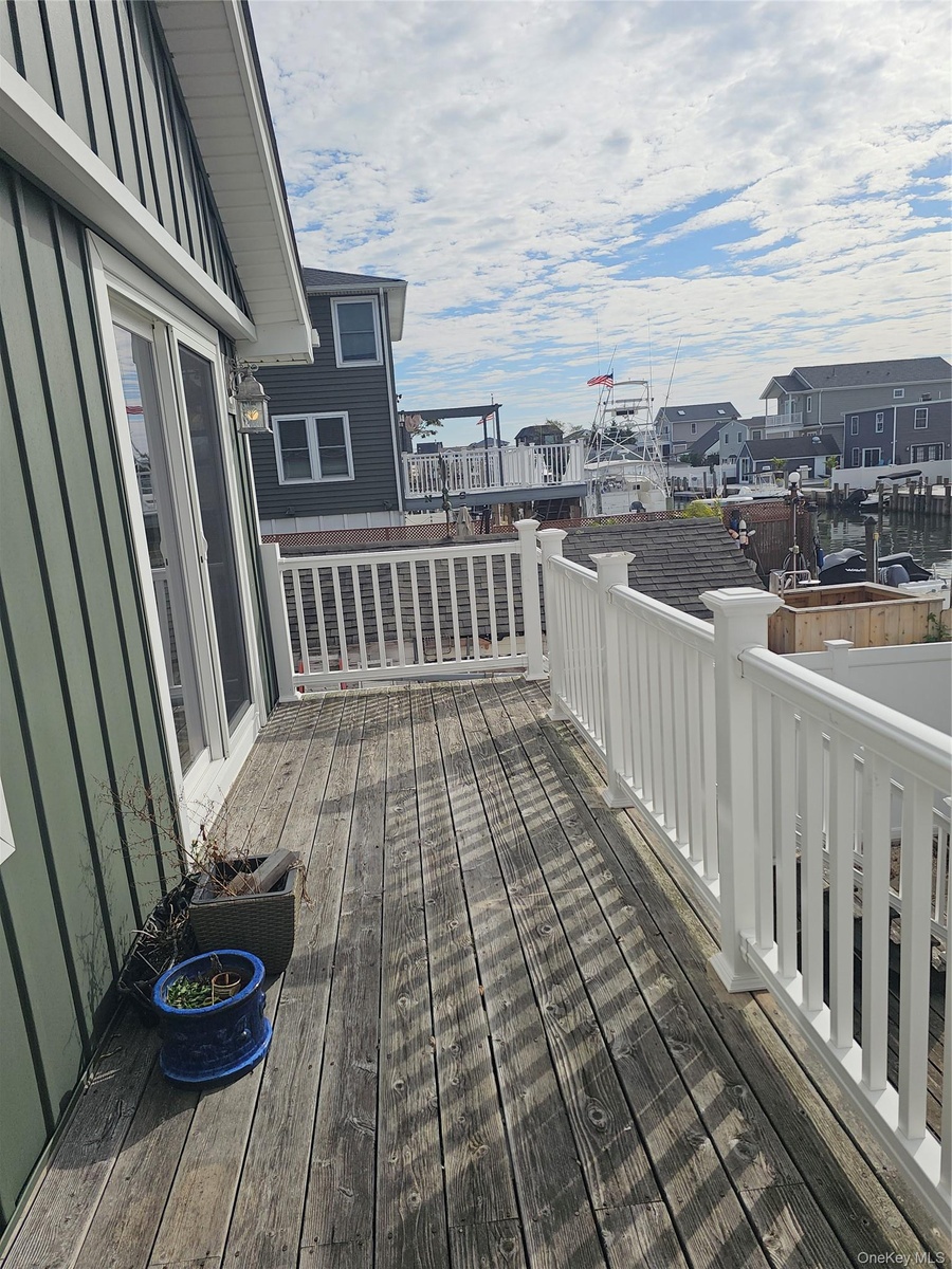 Outdoor deck featuring wood-finish decking, white railings, and attached exterior lighting