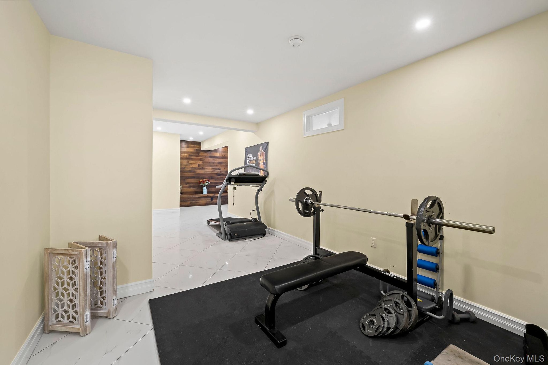 Large-format tile flooring, recessed ceiling lighting, and a prominent wood-panel feature wall