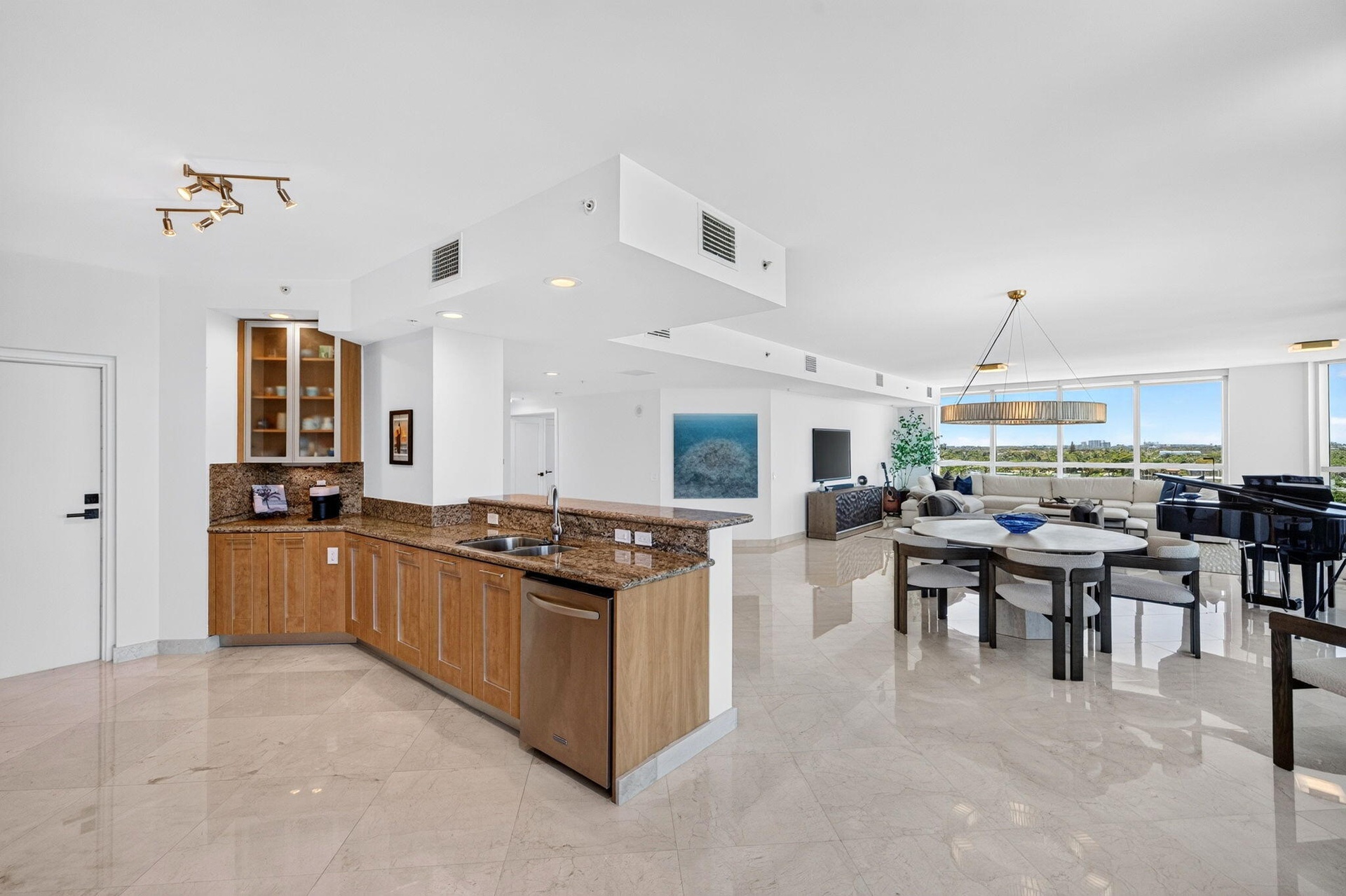 Open-concept living space with polished marble flooring, and extensive windows with motorized blinds