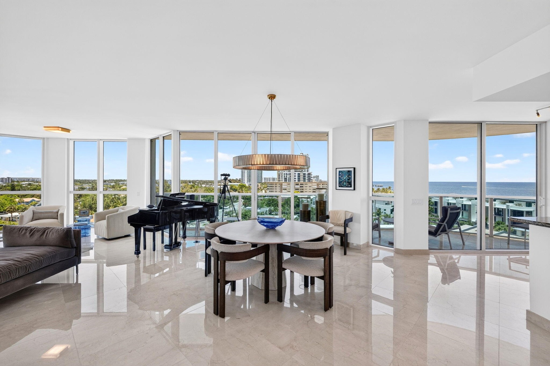 Expansive living area with polished tile flooring, floor-to-ceiling windows, and abundant natural light