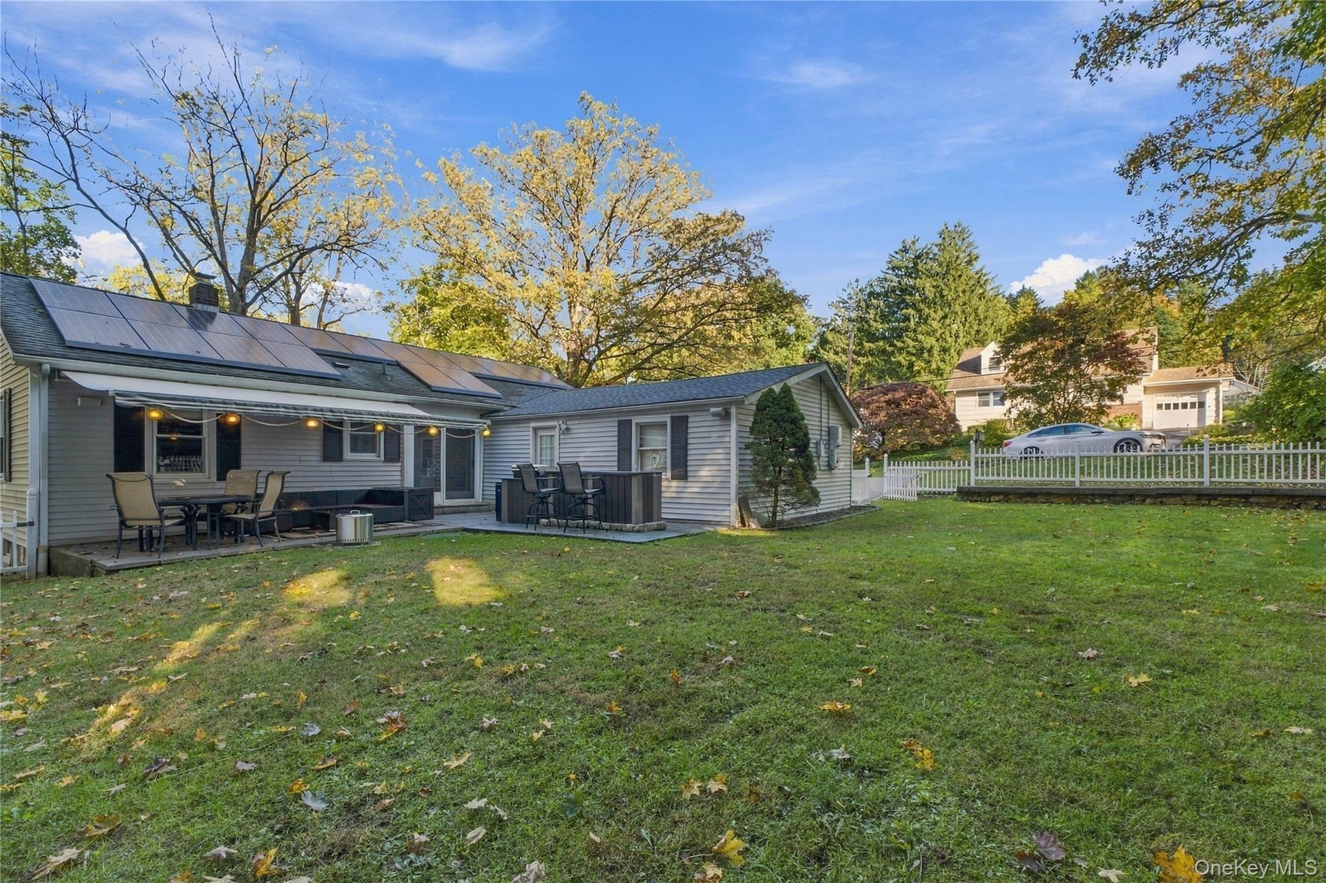 Back yard with stone patio and retractable awning