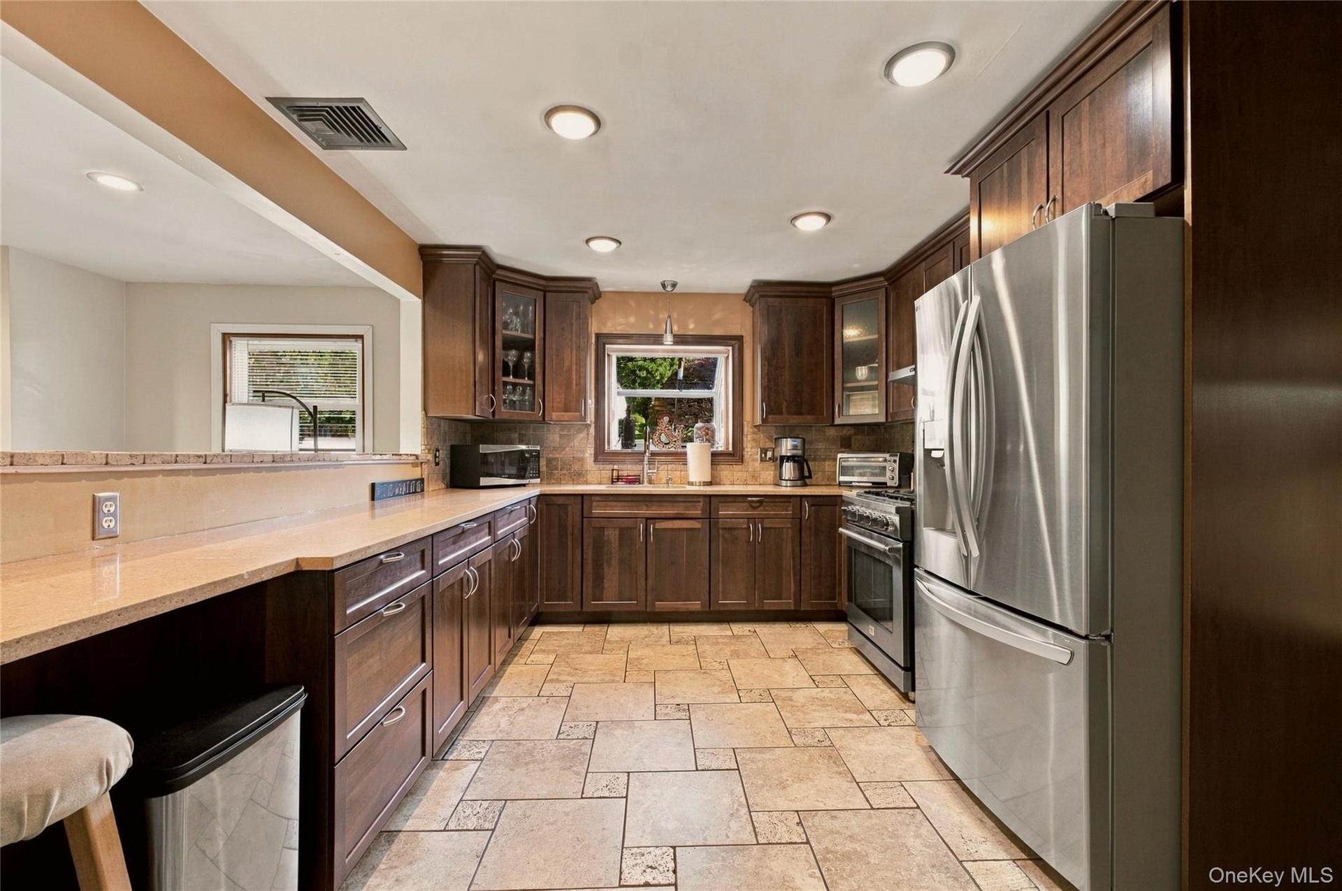 Gourmet kitchen with wood cabinets, stainless steel appliances, and recess lighting