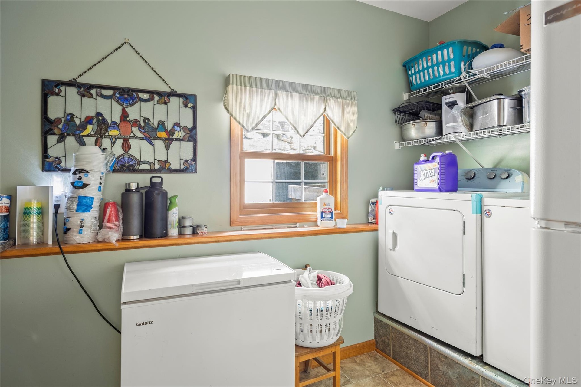 Laundry area featuring washing machine and clothes dryer and tile patterned flooring