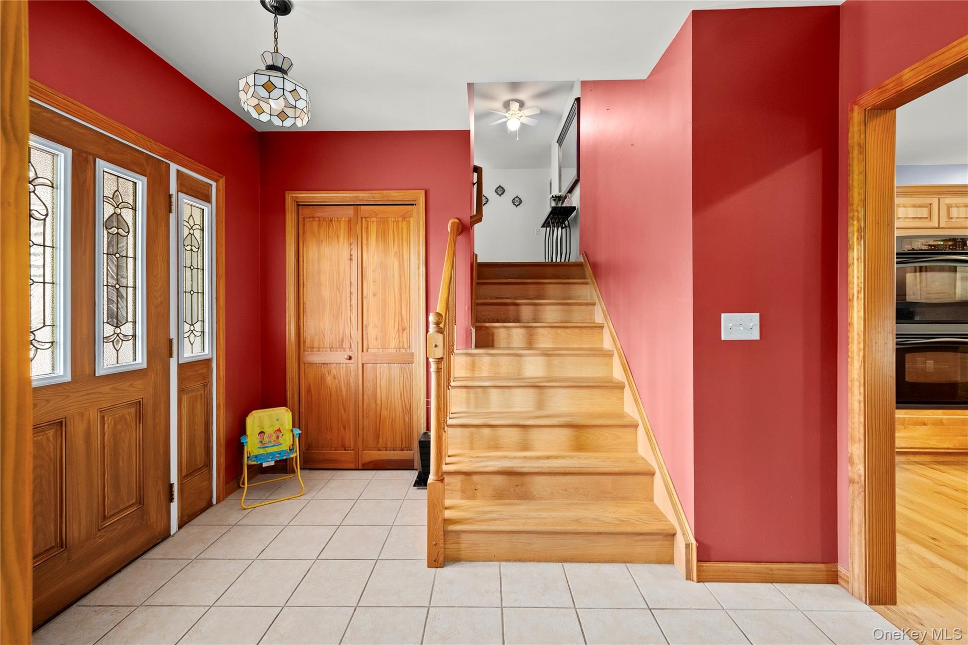 Foyer featuring stairs, a ceiling fan, and light tile patterned flooring