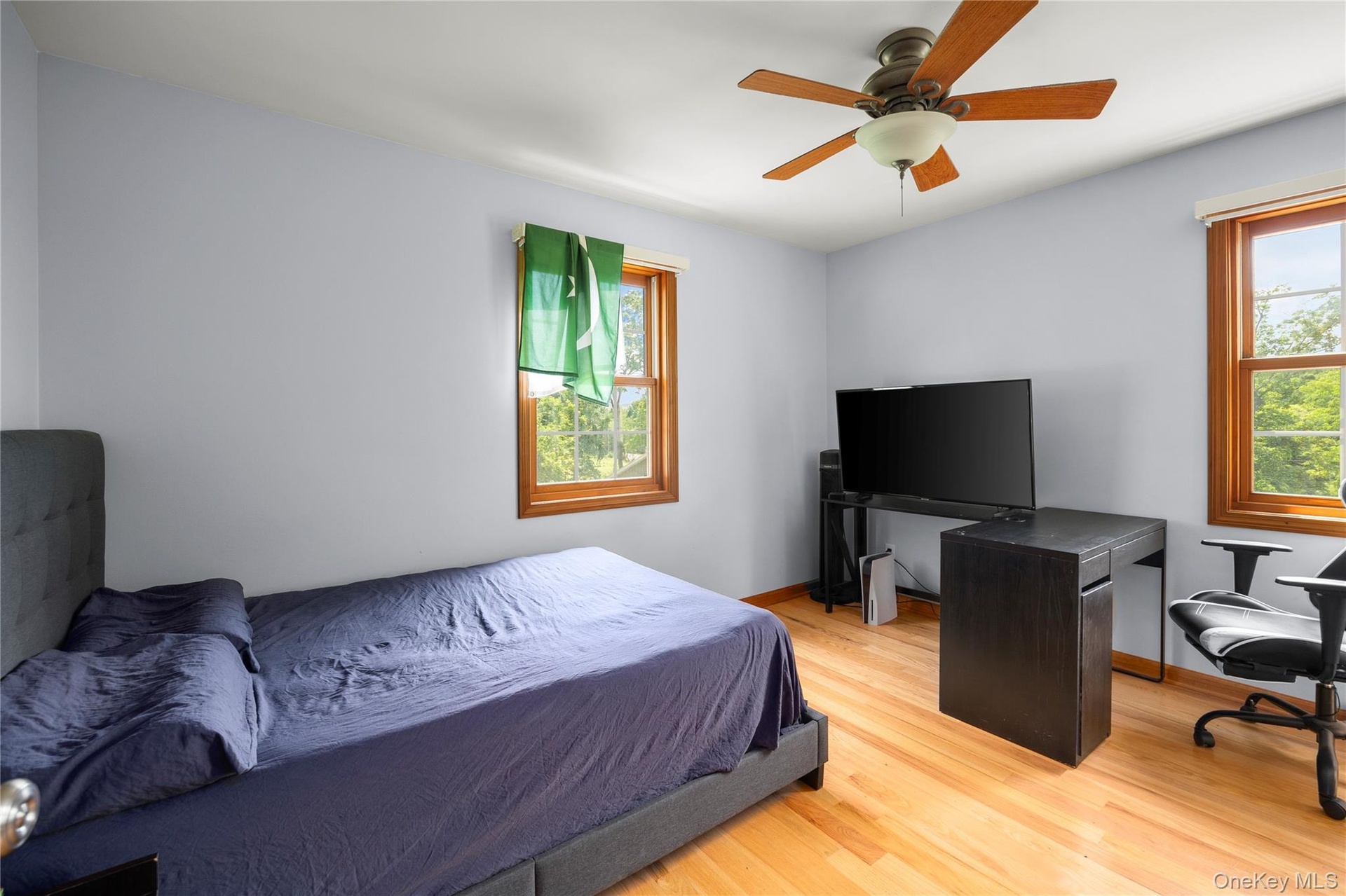 Bedroom featuring light wood-type flooring, a ceiling fan, and an office area