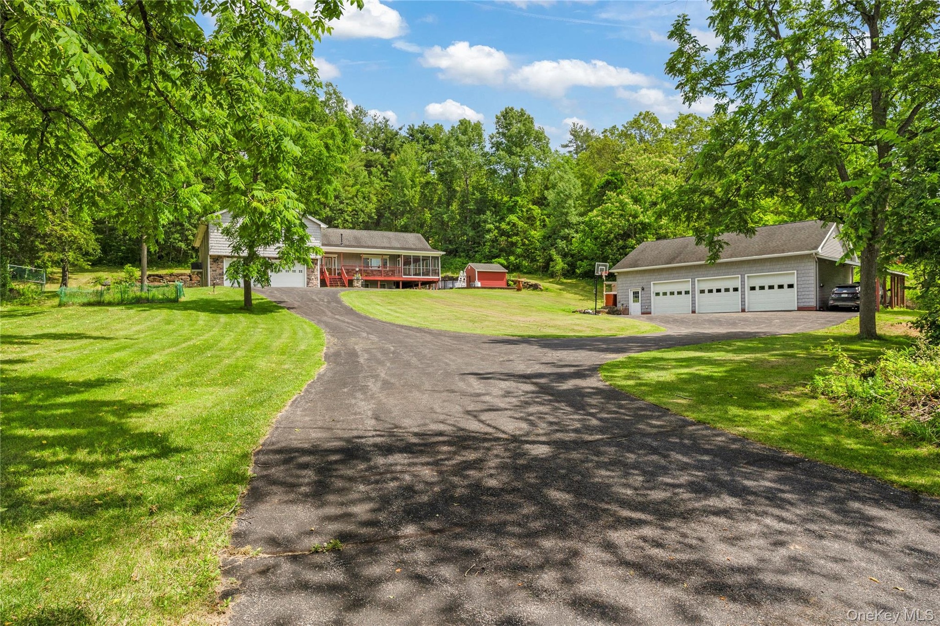 View of front of house featuring an outdoor structure, a front yard, and a garage