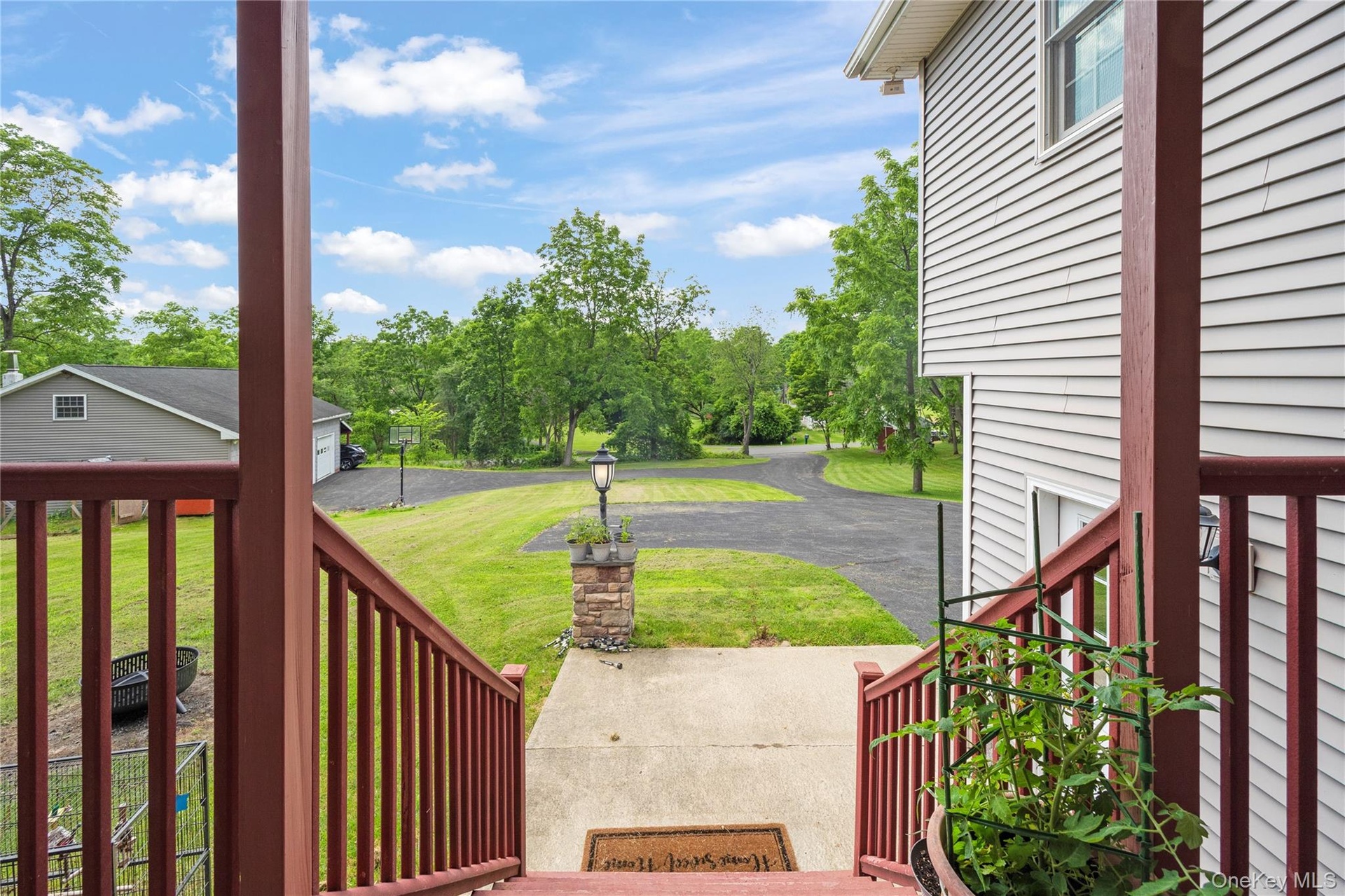 Wooden porch featuring a yard and driveway
