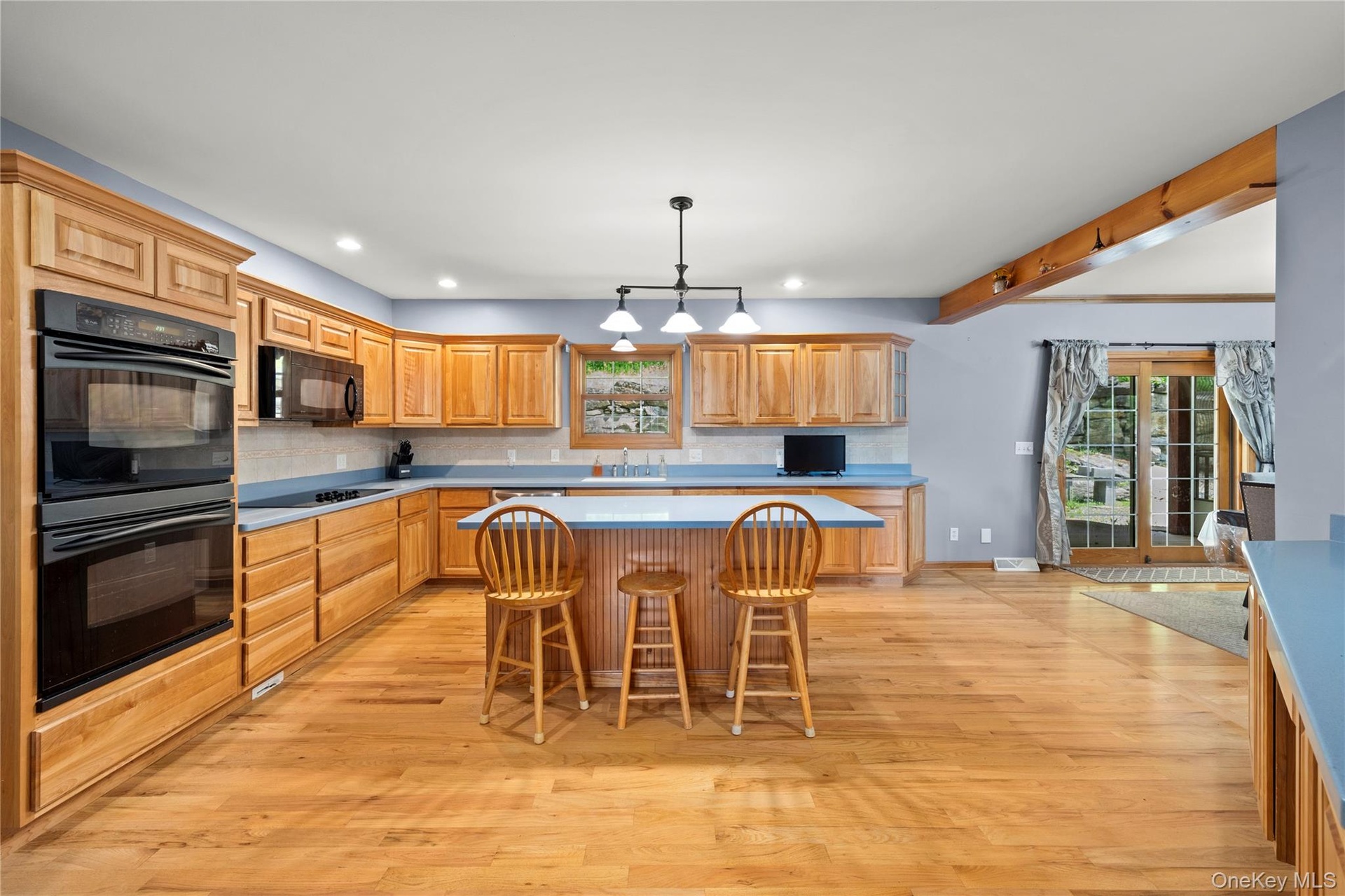 Kitchen featuring  center island, recessed lighting, light wood-type flooring, and backsplash