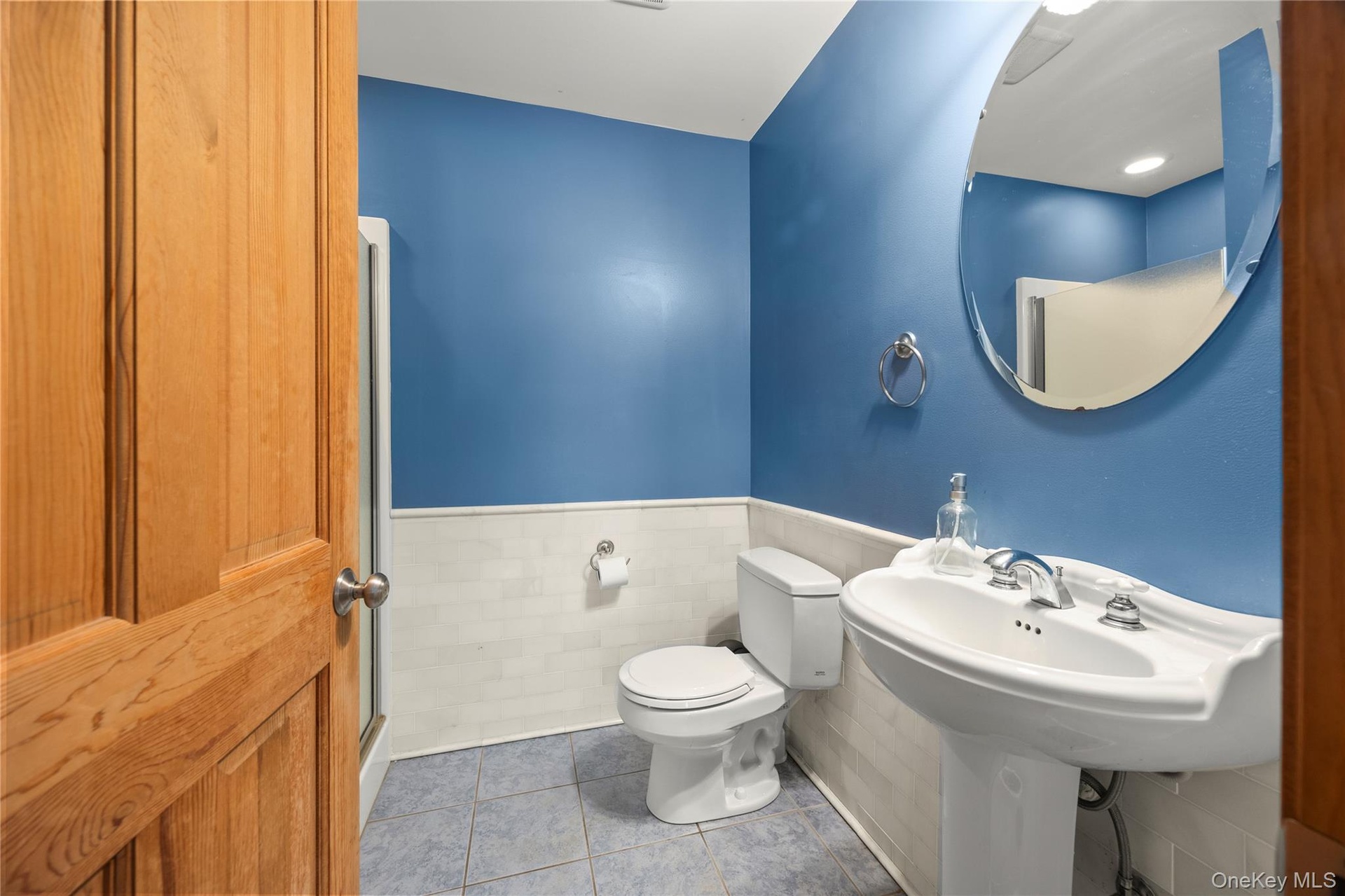 Bathroom with wainscoting and tile patterned flooring