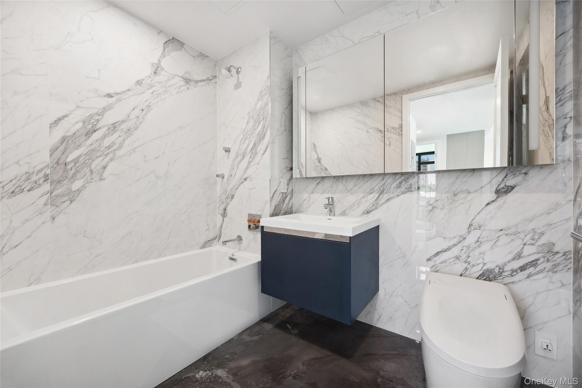 Bathroom featuring tile walls, toilet, shower / bath combination, vanity, and marble finish floors