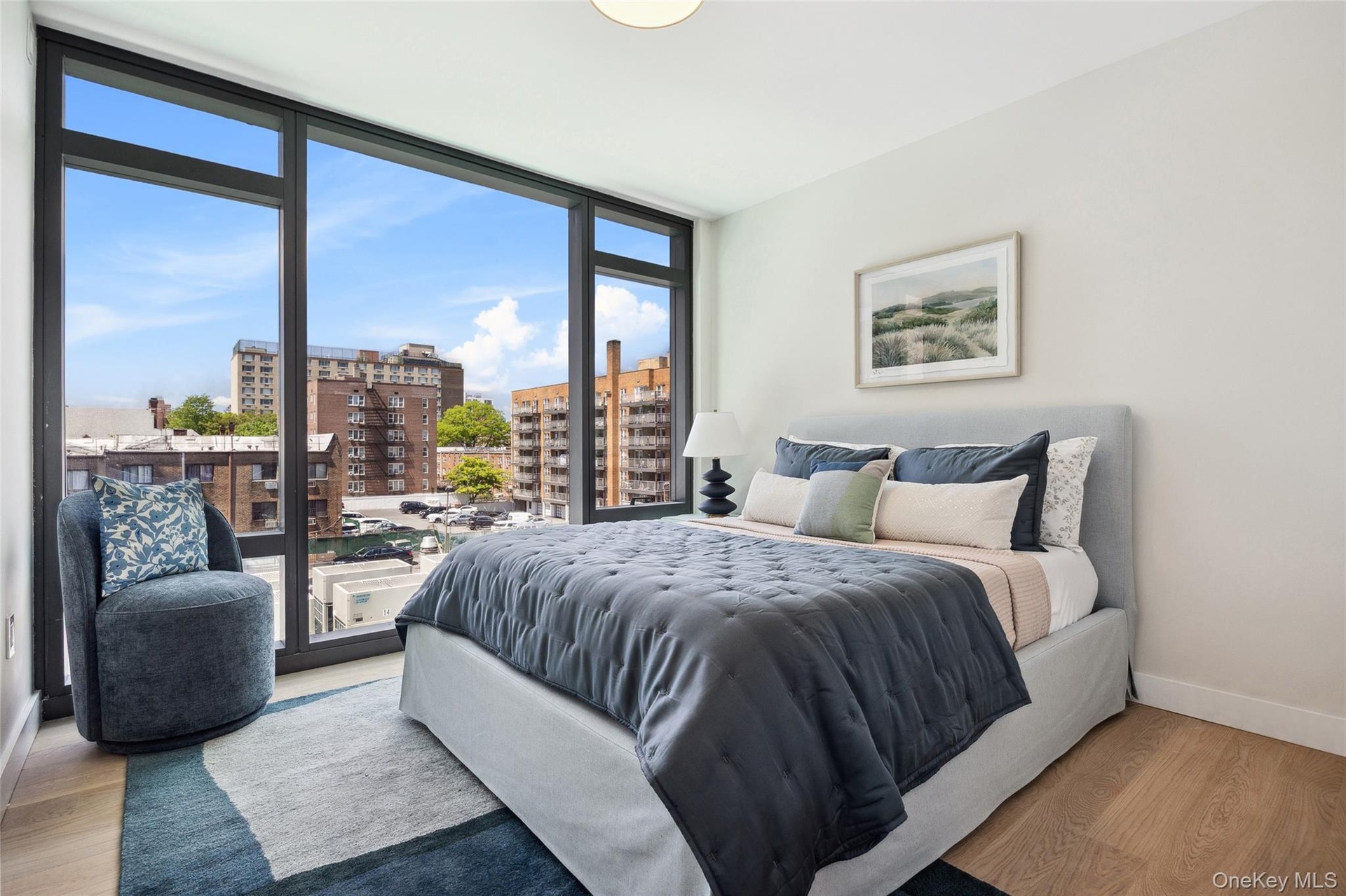 Bedroom featuring a view of city, wood finished floors, baseboards, expansive windows, and access to outside