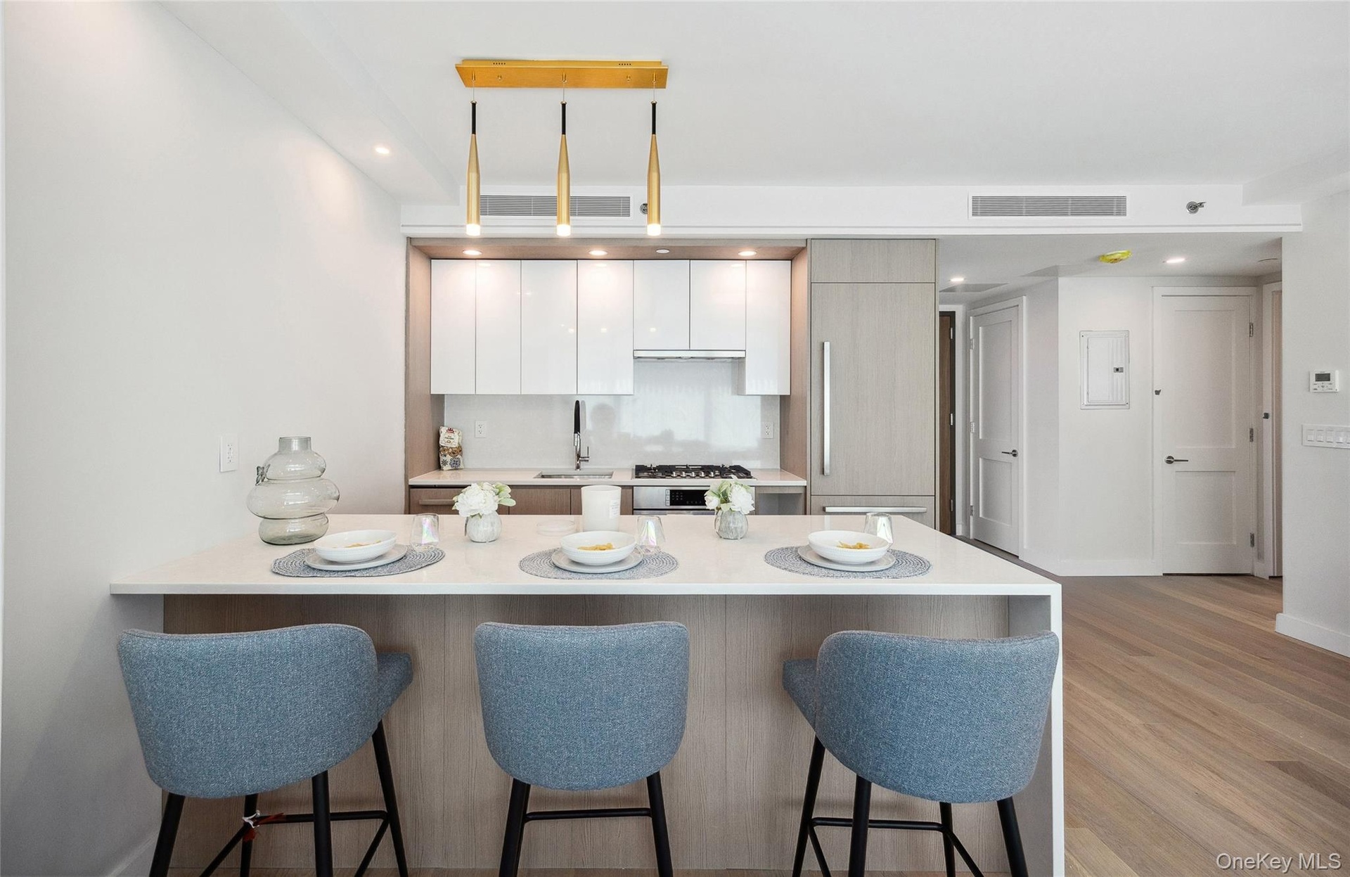Kitchen with a breakfast bar, light countertops, a peninsula, modern cabinets, and recessed lighting