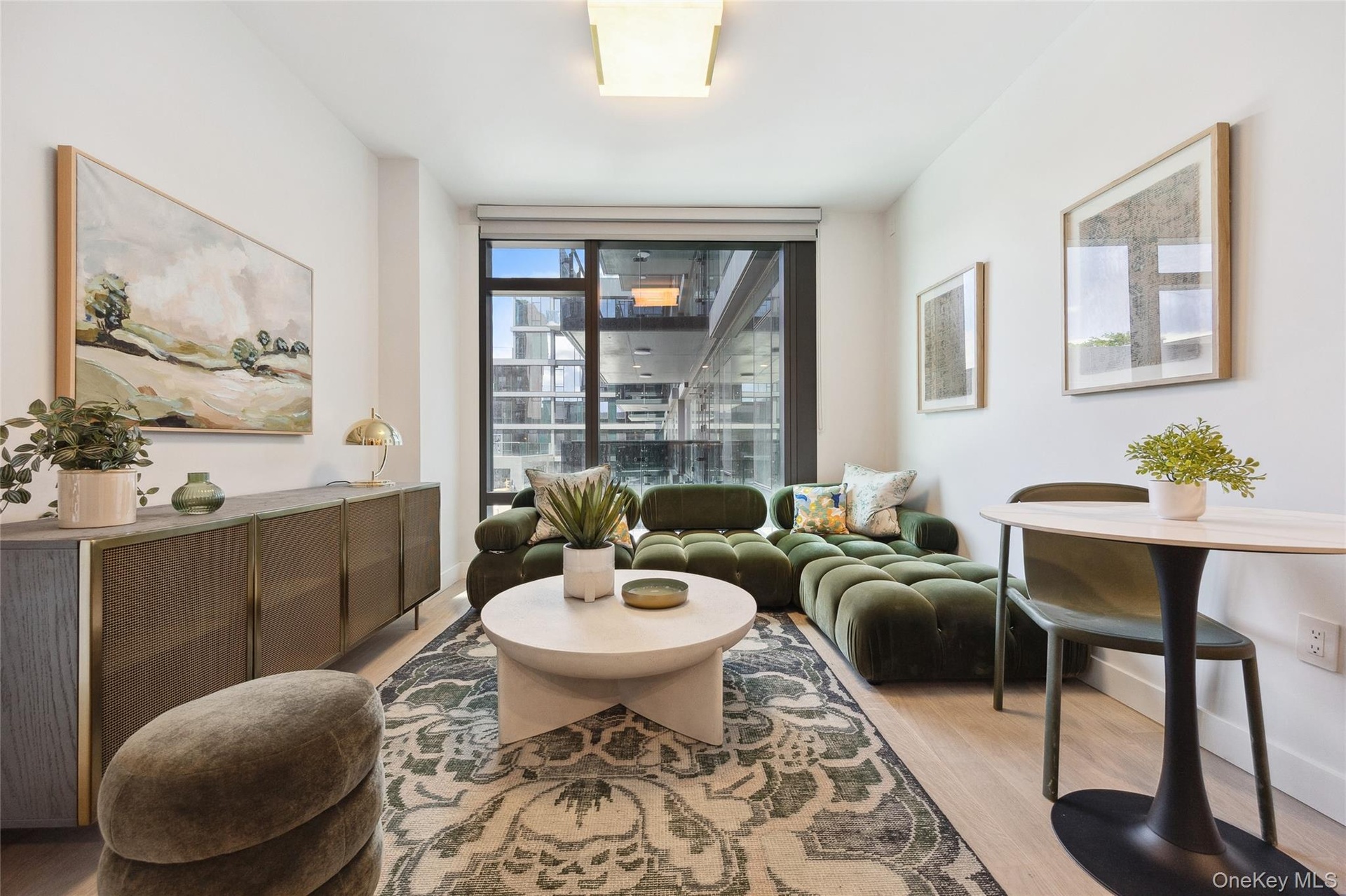 Living area featuring light wood-style flooring, baseboards, and a wall of windows