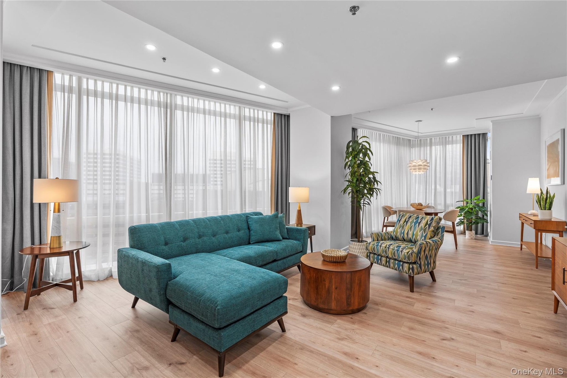 Living area featuring a wall of windows, recessed lighting, and light wood-style floors