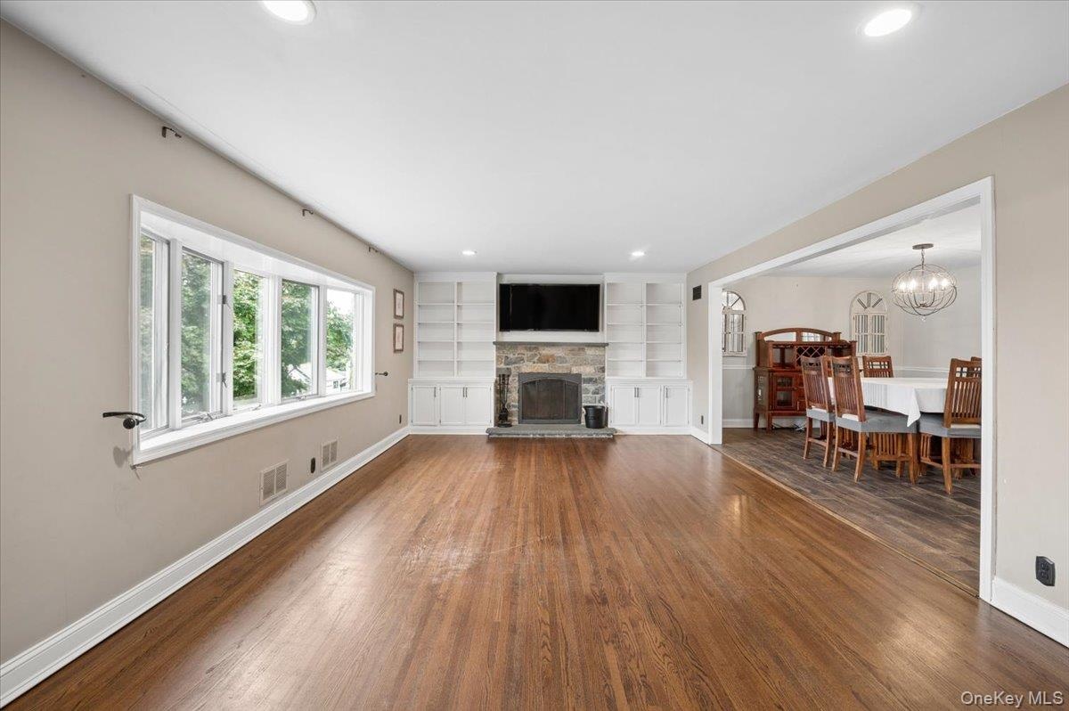 Living room with picture window and built-ins surrounding a wood burning fireplace.
