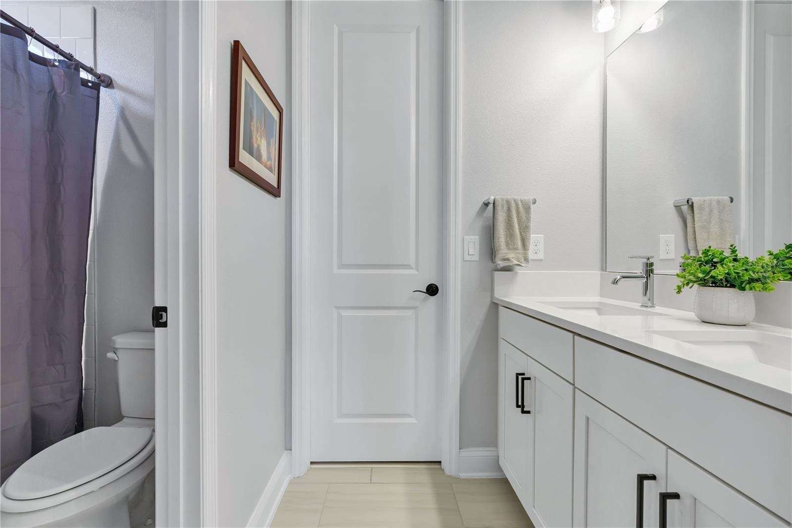 Full bath with shower and tub combination and quartz vanity.