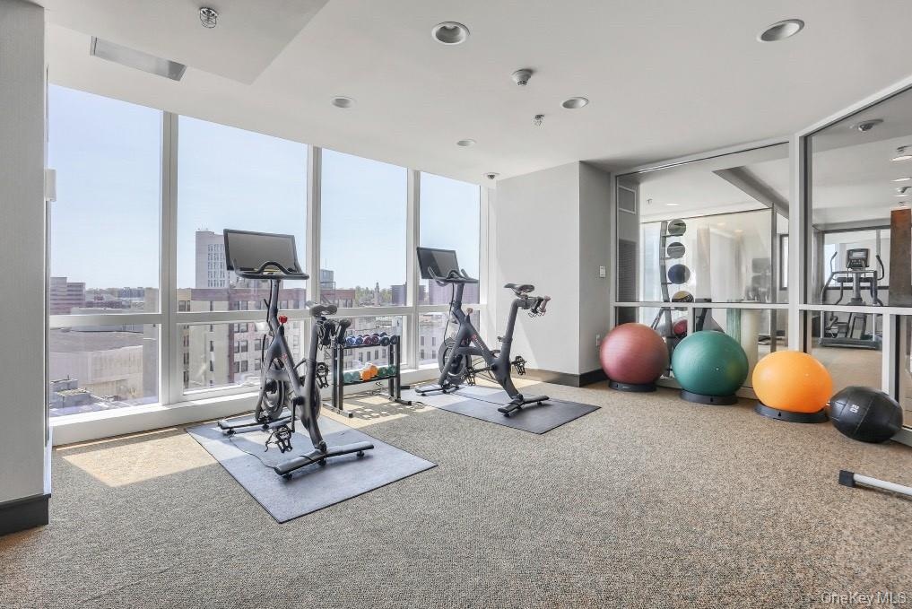 Workout area with floor to ceiling windows and recessed lighting