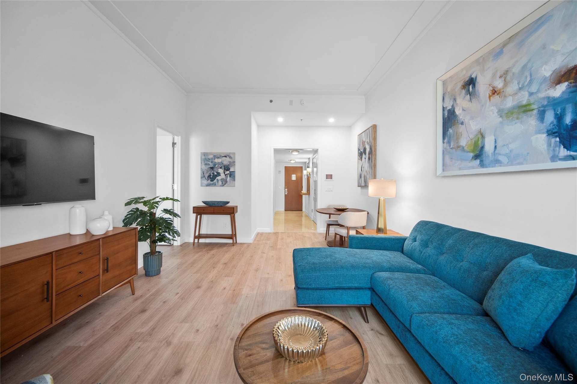 Living room with crown molding and light wood-type flooring