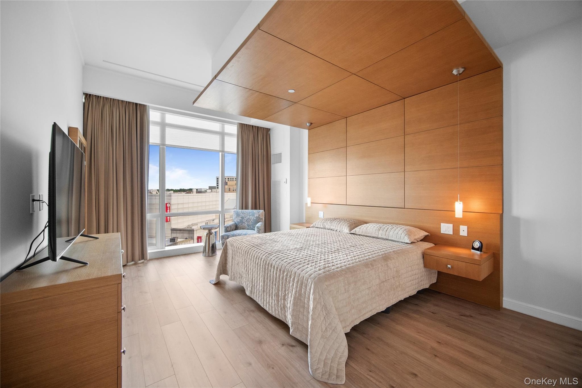 Bedroom featuring expansive windows and light wood-style floors