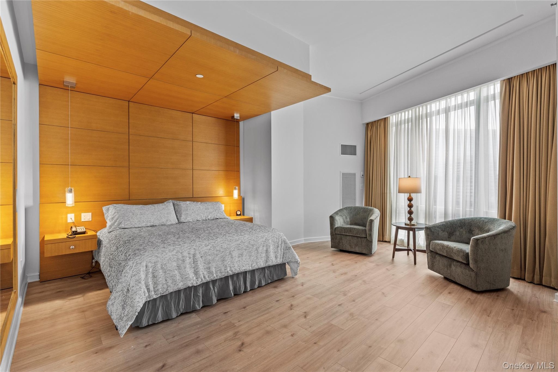 Bedroom with light wood-style floors, visible vents, and baseboards