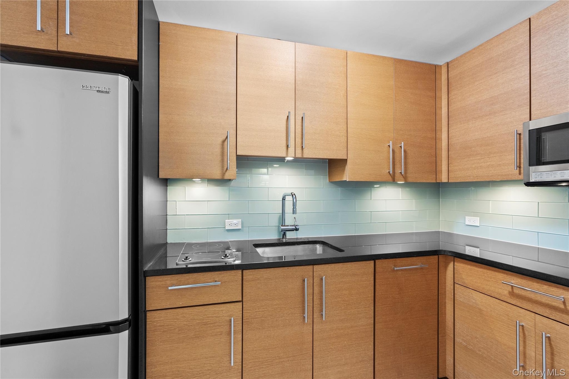 Kitchen featuring appliances with stainless steel finishes, a sink, and backsplash