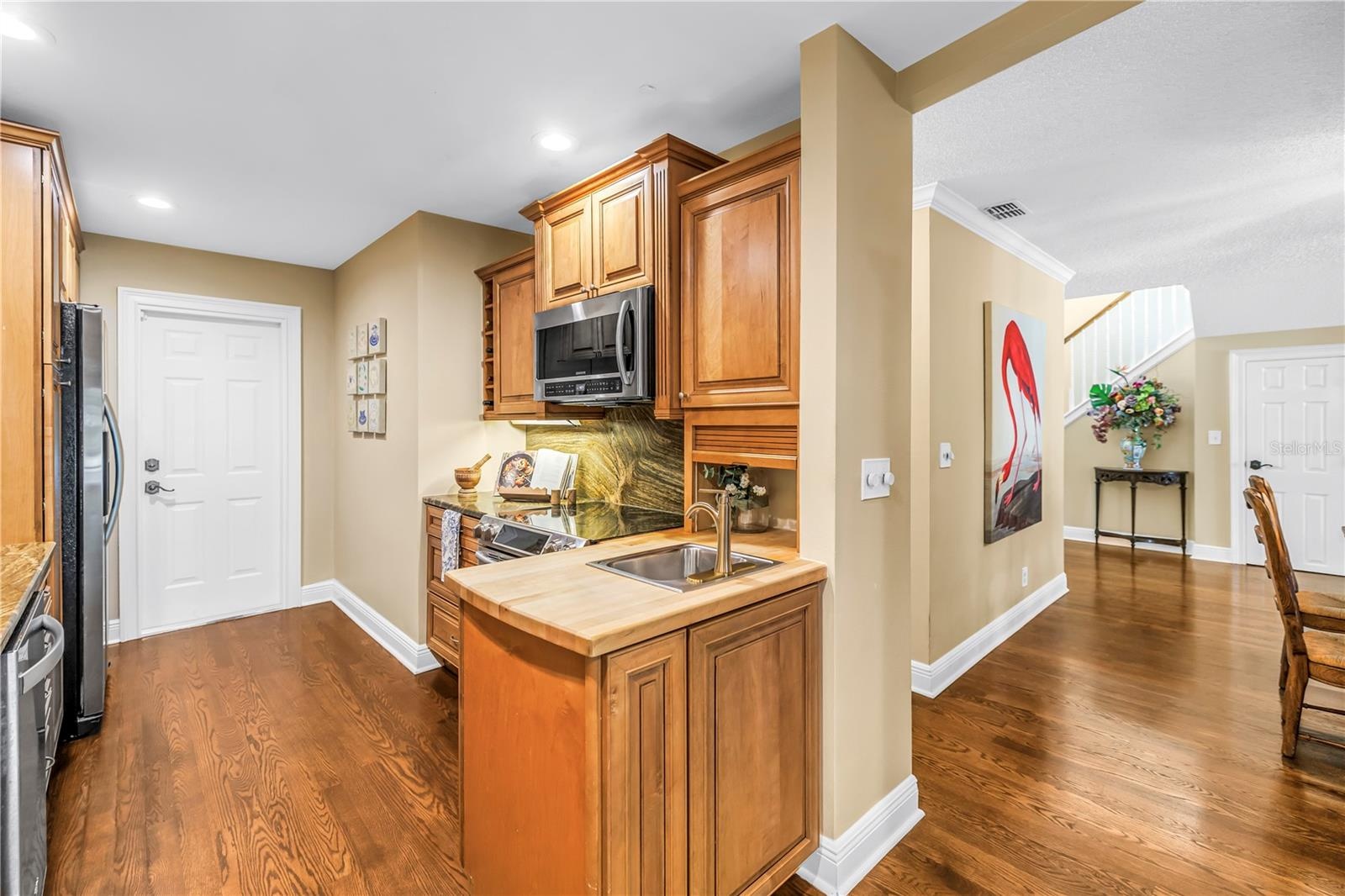 The kitchen features an efficient workspace equipped with a range, a convection microwave, and a preparation sink with an integrated butcher block cou