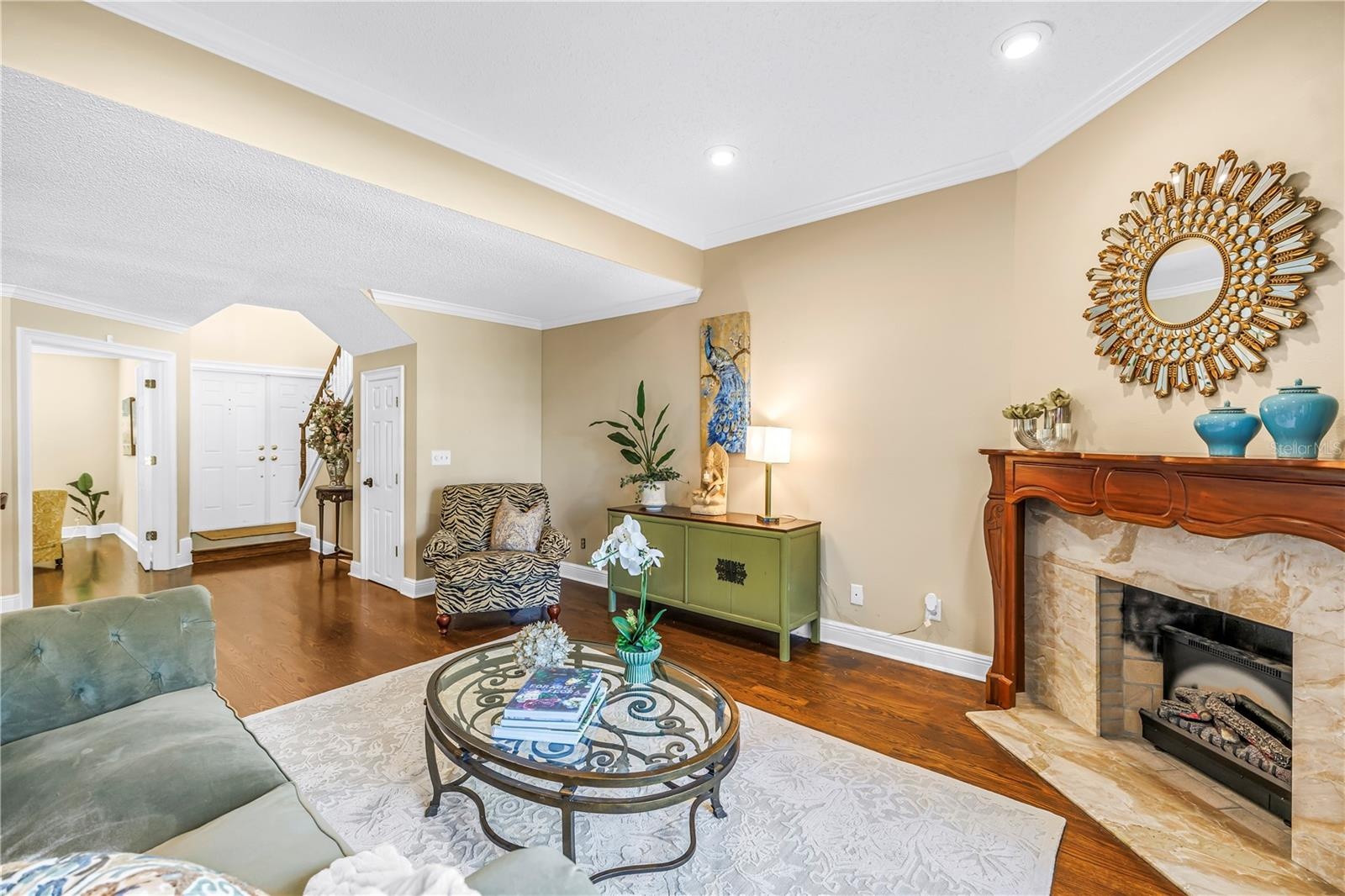 The open formal living area provides an ideal entry for guests, featuring panoramic lake views and an elegant marble fireplace.