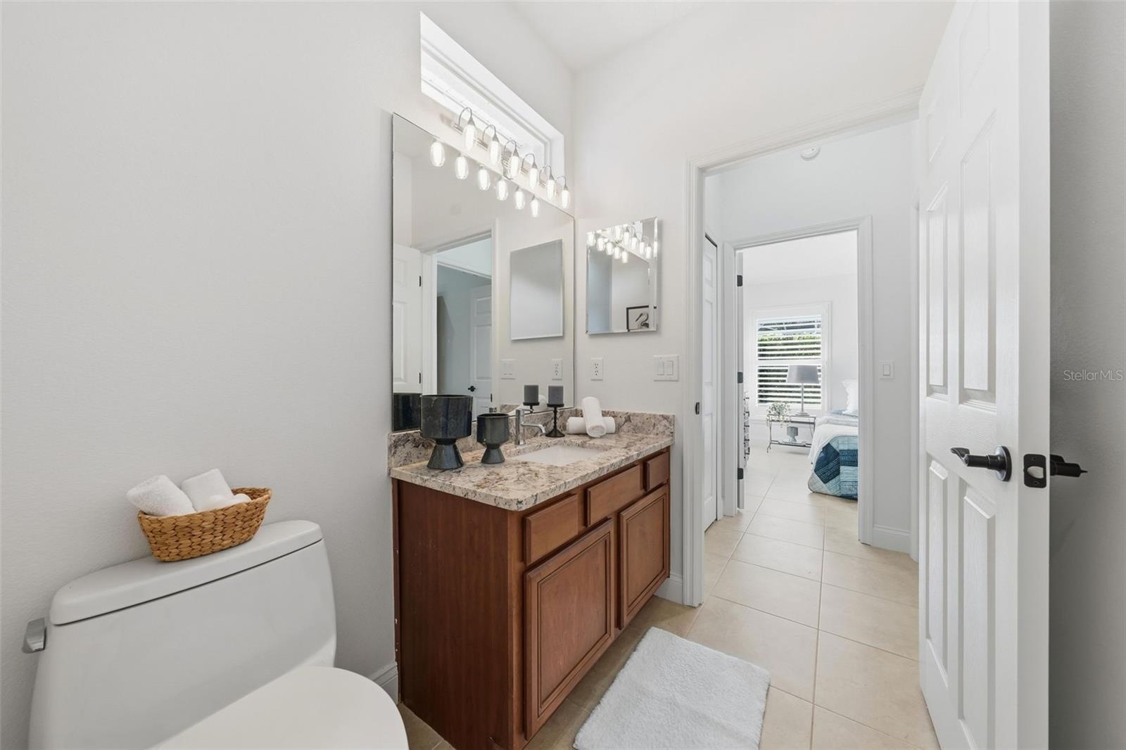 POOL BATH WITH 4TH BEDROOM IN THE BACKGROUND AND A DOOR SEPARATING FROM THE FAMILY ROOM