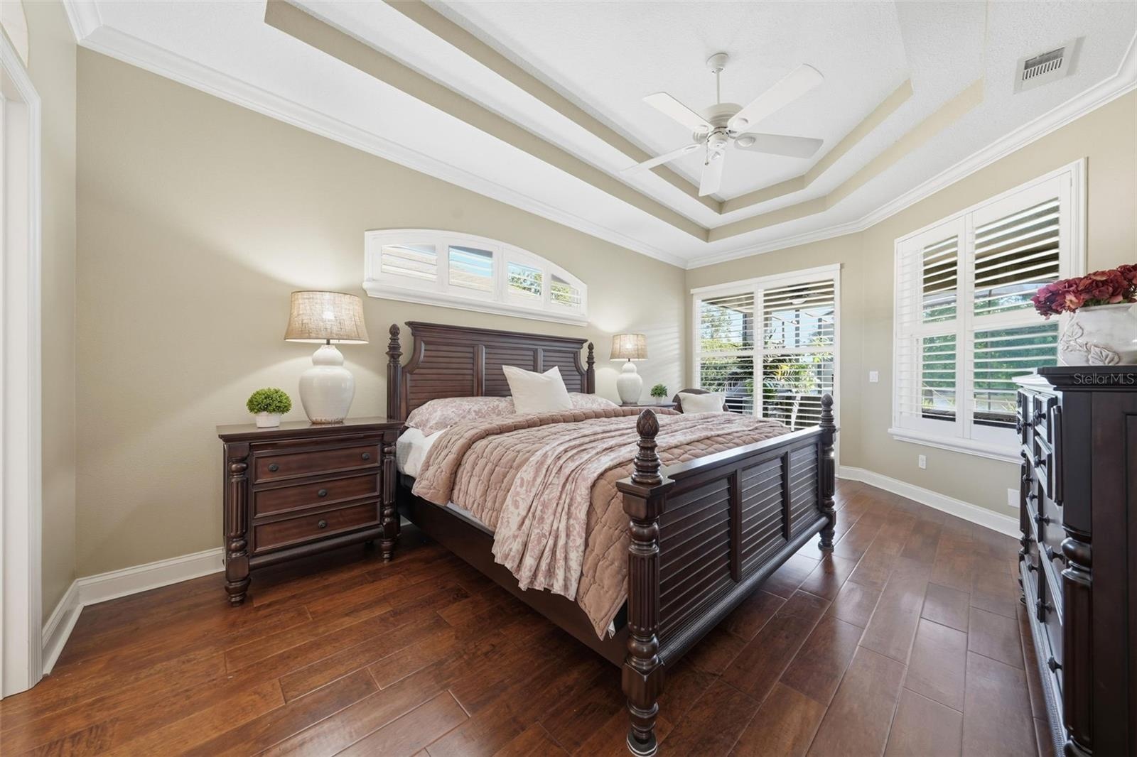 PRIMARY BEDROOM WITH DOUBLE TRAY CEILING AND SLIDING DOORS OUT TO THE POOL