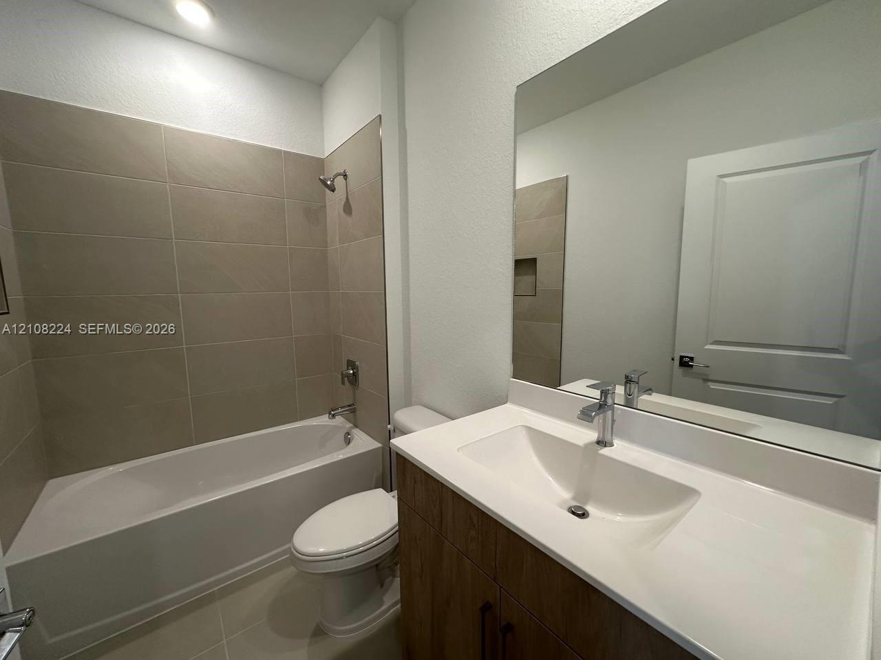 Neutral-toned carpeting, two dual-pane windows, and a classic two-panel interior door